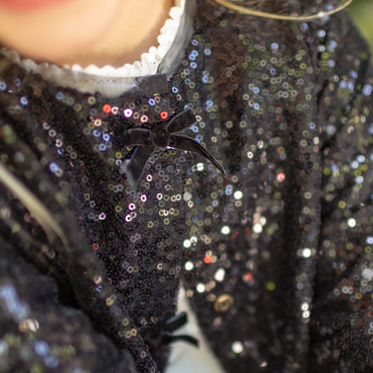 Zoom d'un enfant portant le veston noir à paillettes, enfant