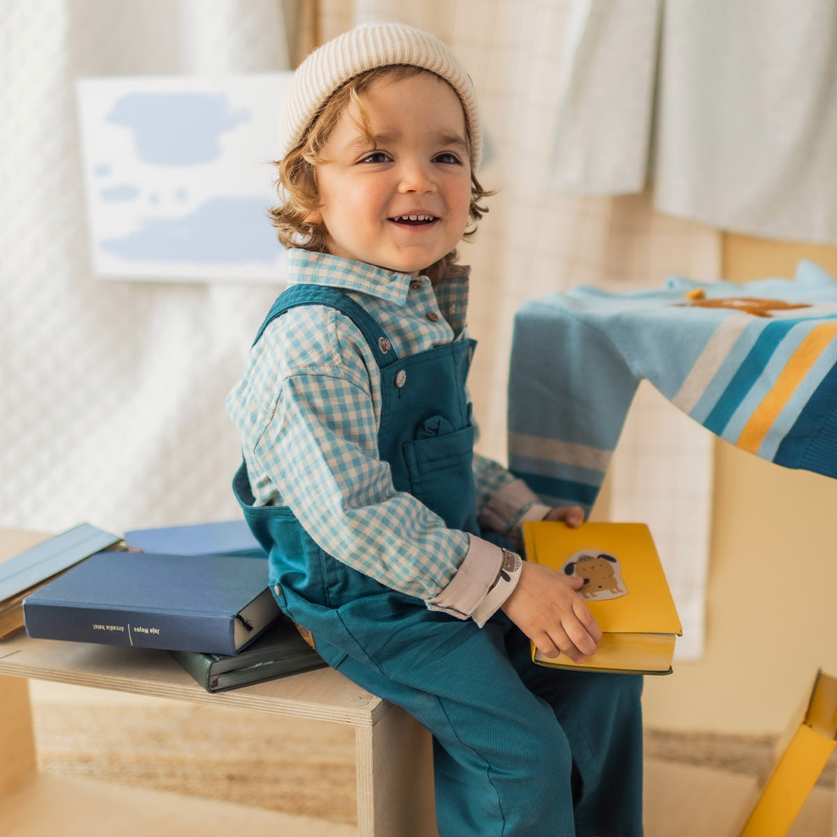 Chemise bleue à carreaux en flanelle brossée pour bébé à manches longues, portée sous une salopette bleue.