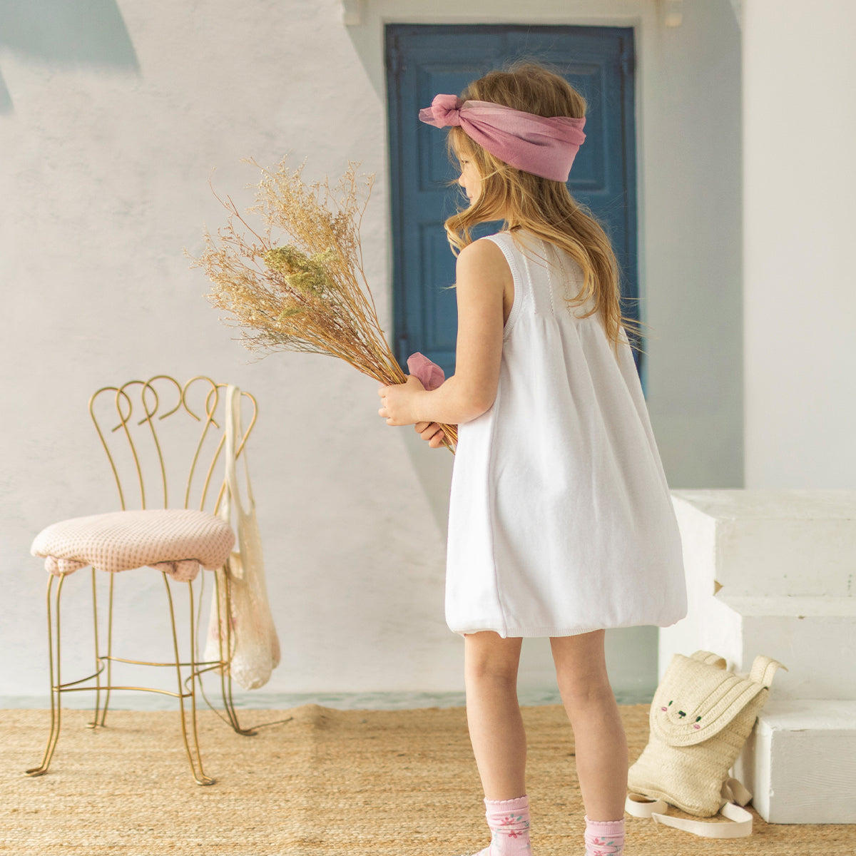 Look de dos de la robe blanche en tricot avec broderies florales, enfant