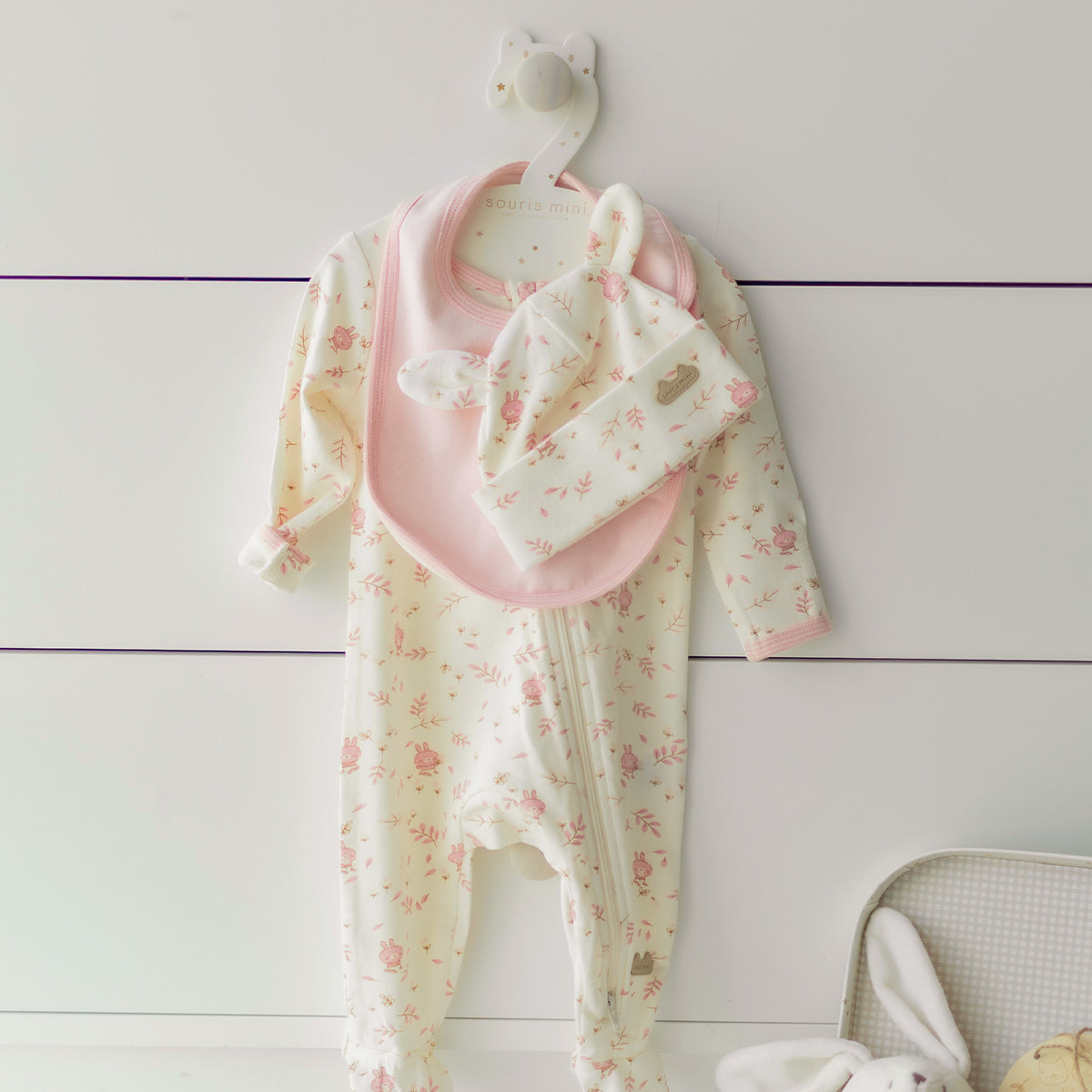 Présentation de l’ensemble pyjama, bavoir et chapeau crème et rose, naissance