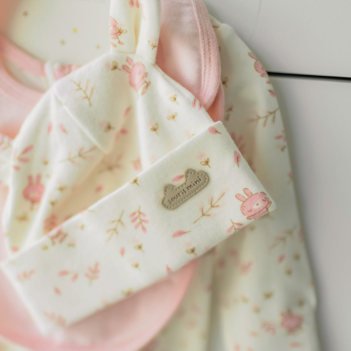Zoom bonnet de l’ensemble pyjama, bavoir et chapeau crème et rose, naissance