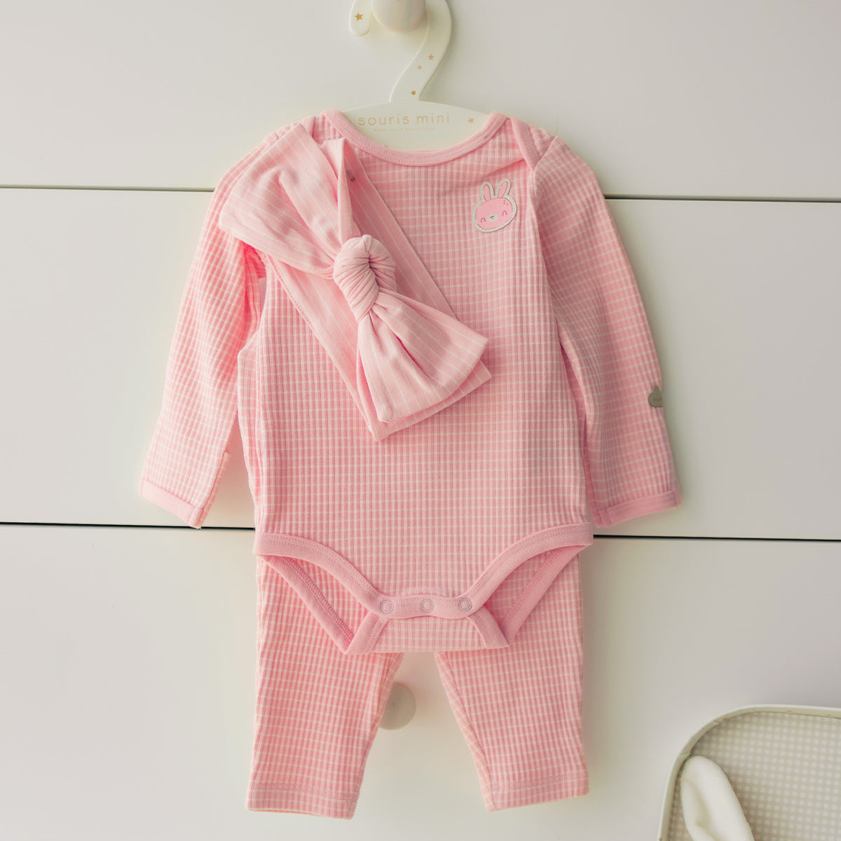 Présentation de l’ensemble cache-couche, pantalon et bandeau rose, naissance
