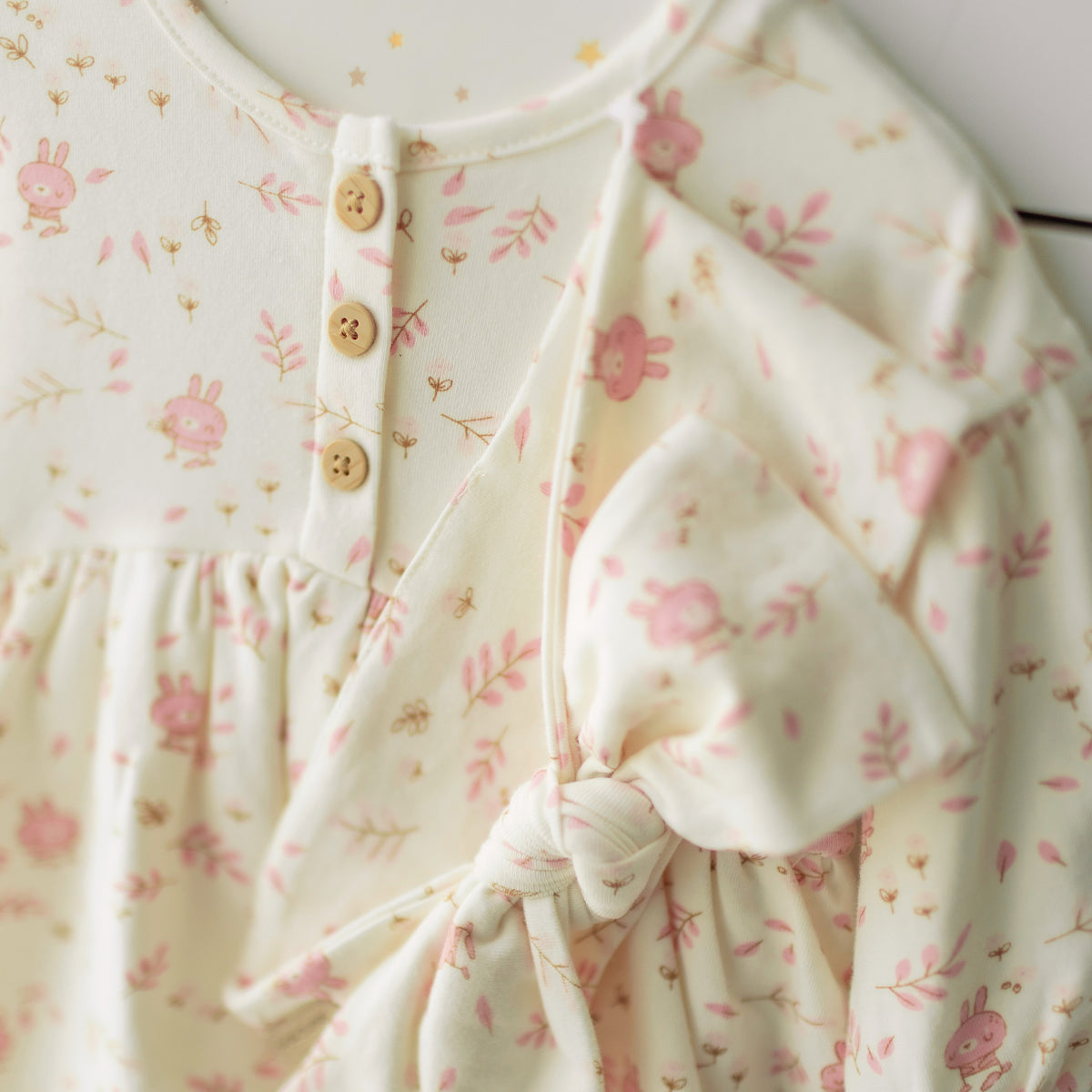 Zoom détails de l’ensemble robe et bandeau crème avec motifs, naissance