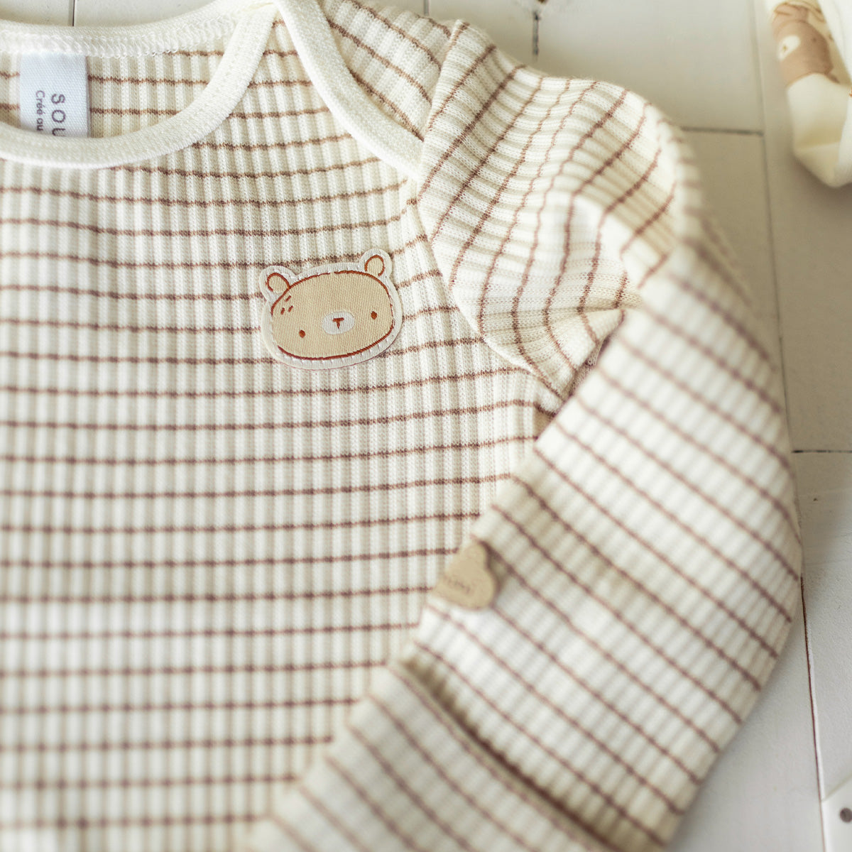 Zoom détails du cache-couche du coffret cadeau crème et beige « Le Signature » (11 pièces), naissance