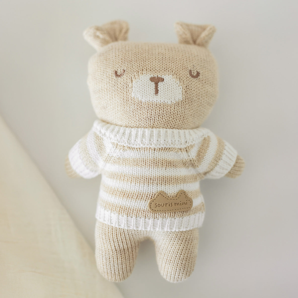 Présentation de la peluche beige en tricot, naissance