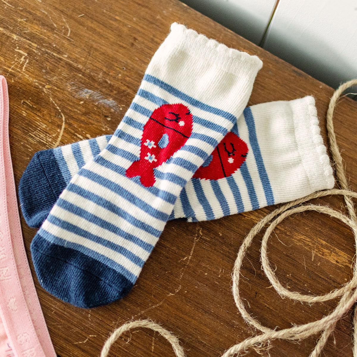 Présentation des chaussettes blanches et bleues à rayures avec poissons, enfant