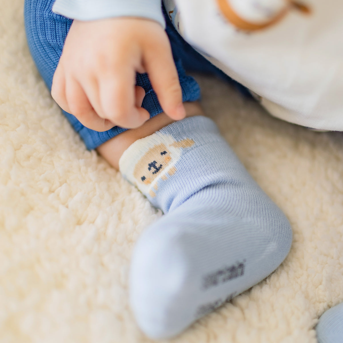 Photo d'un enfant portant les chaussettes bleues avec mouton, naissance