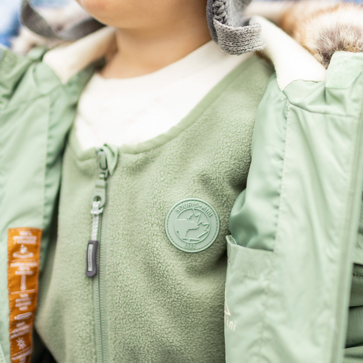 Photo d'un bébé portant l'habit de neige deux pièces vert, bébé