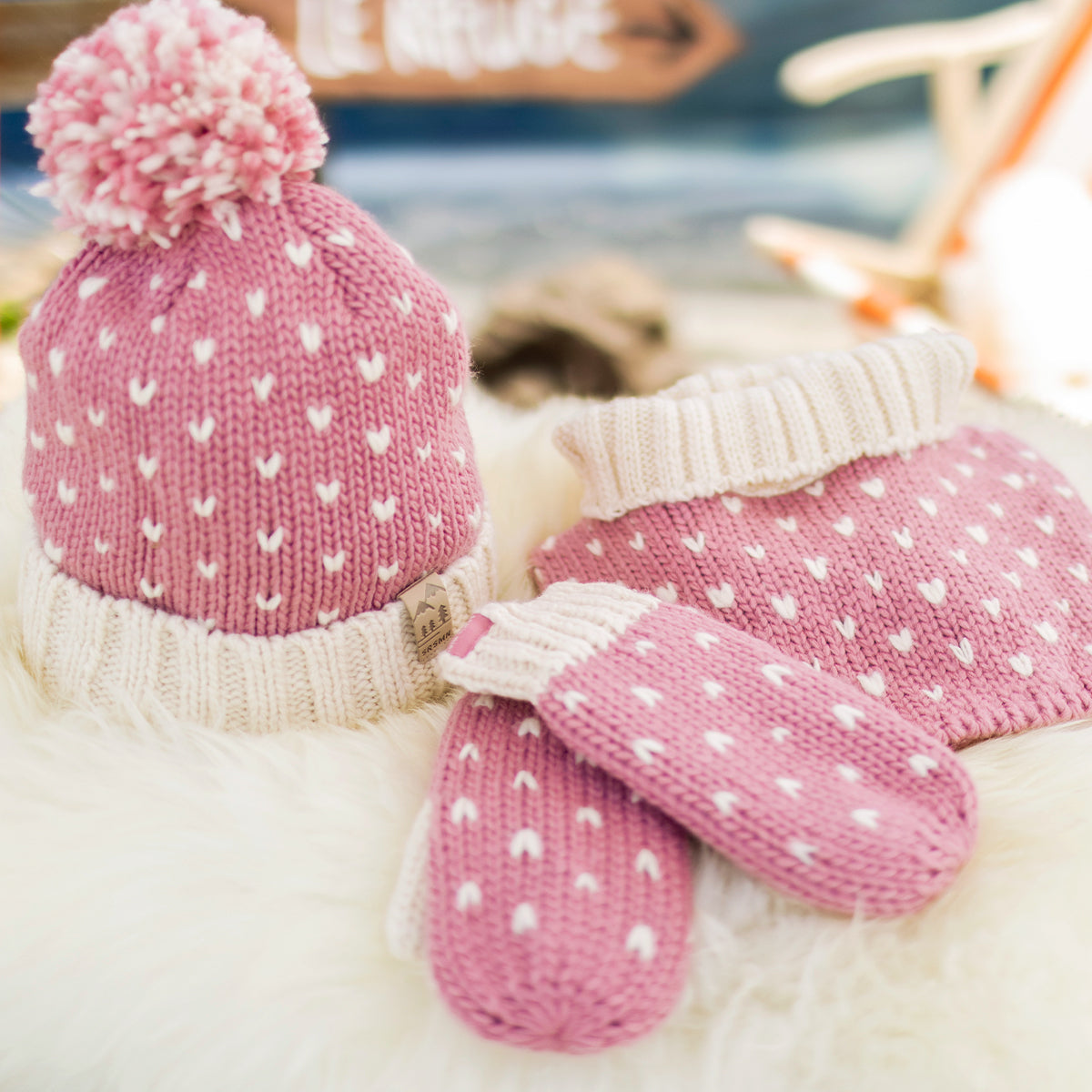 Présentation de la tuque rose et crème en tricot avec cœurs, enfant