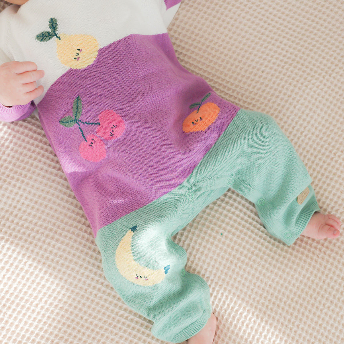 Cream, purple and turquoise knit jumpsuit with fruity patterns, newborn
