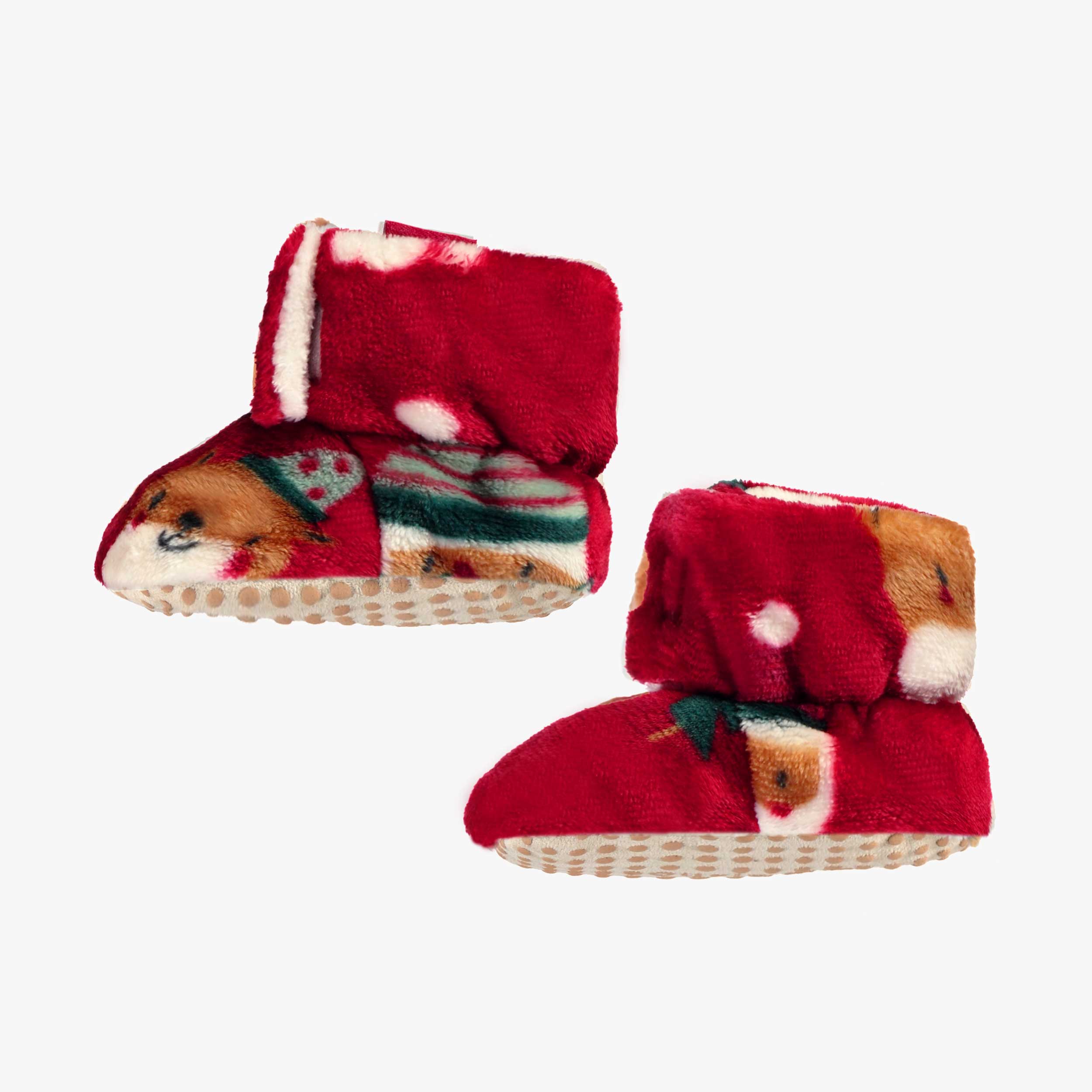 Vue de côté de la pantoufles rouges en peluche avec motifs des Fêtes, bébé