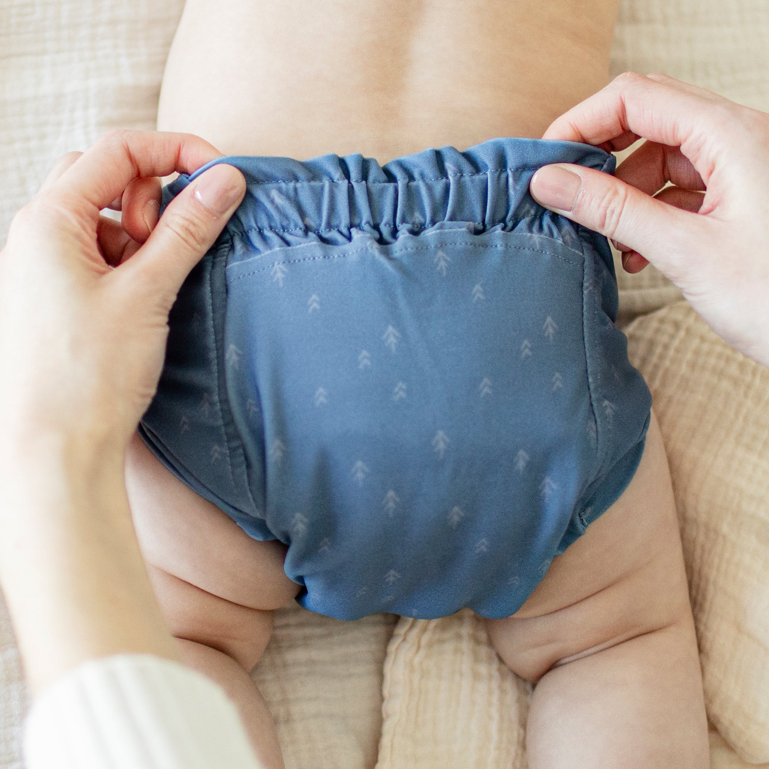 Dos de la couche réutilisable ultramince bleu à motif de flèches, bébé