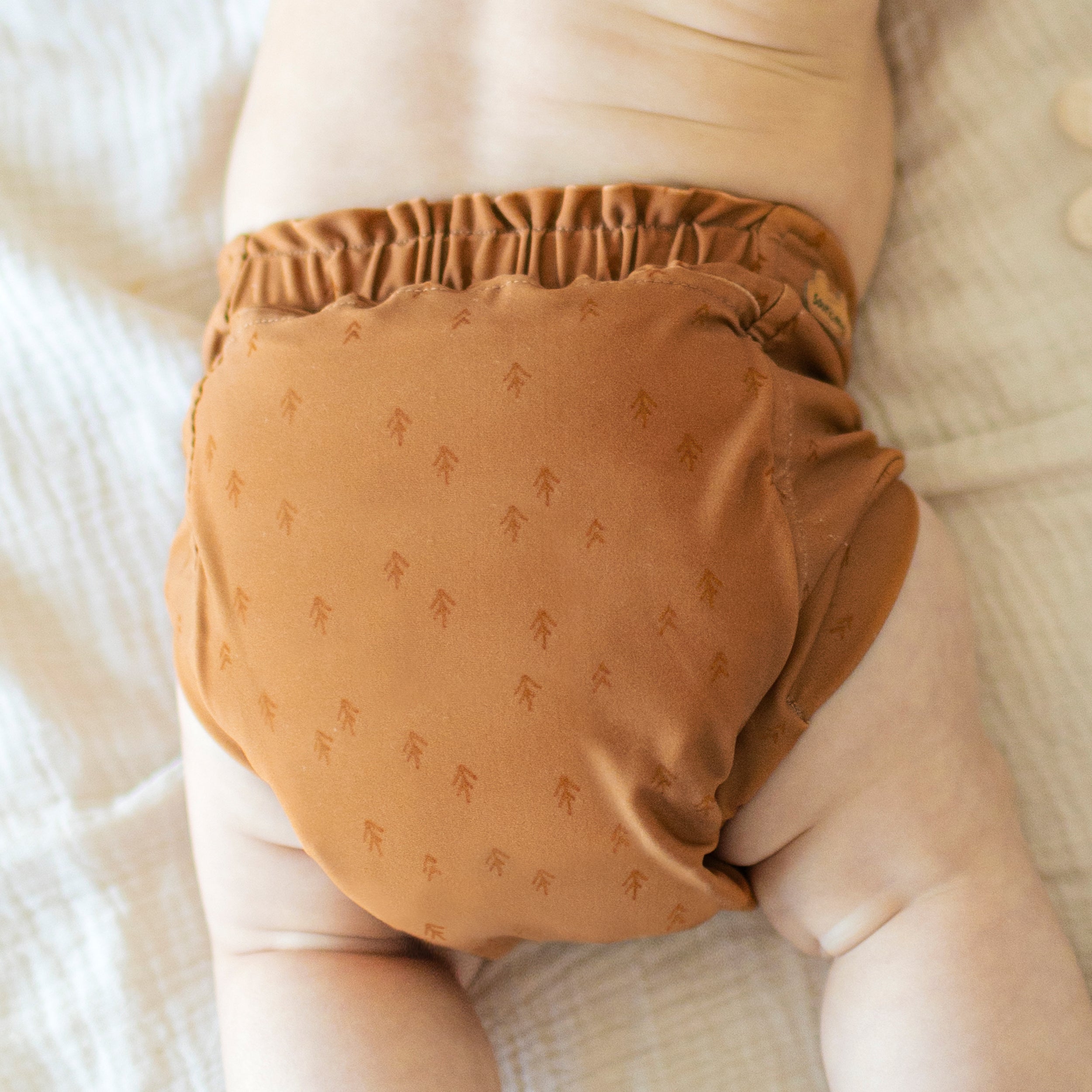 Dos de la couche réutilisable ultramince caramel à motif de flèches, bébé