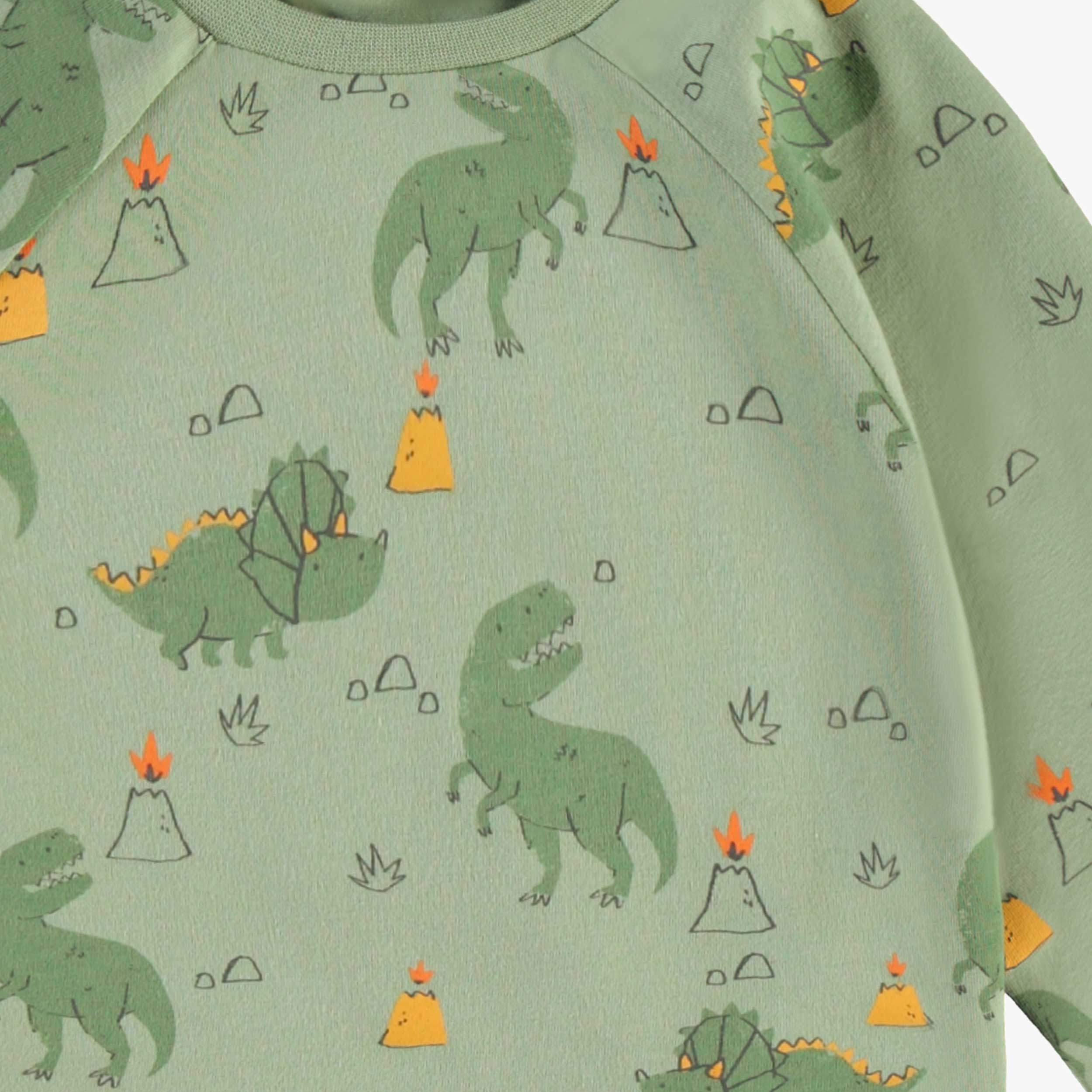 Zoom du pyjama deux pièces vert à motifs de dinosaures, bébé
