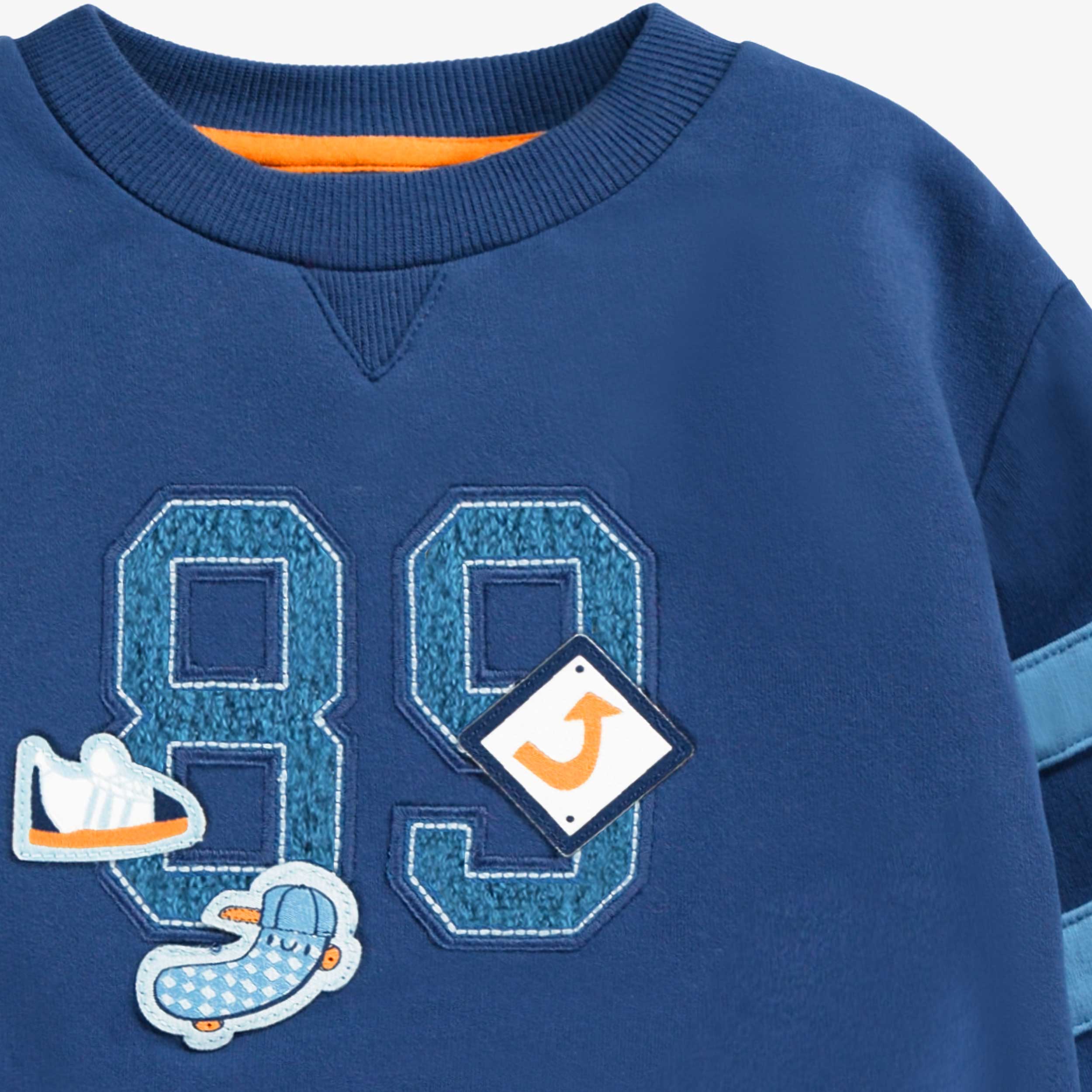 Zoom détails du chandail bleu avec broderie, bébé