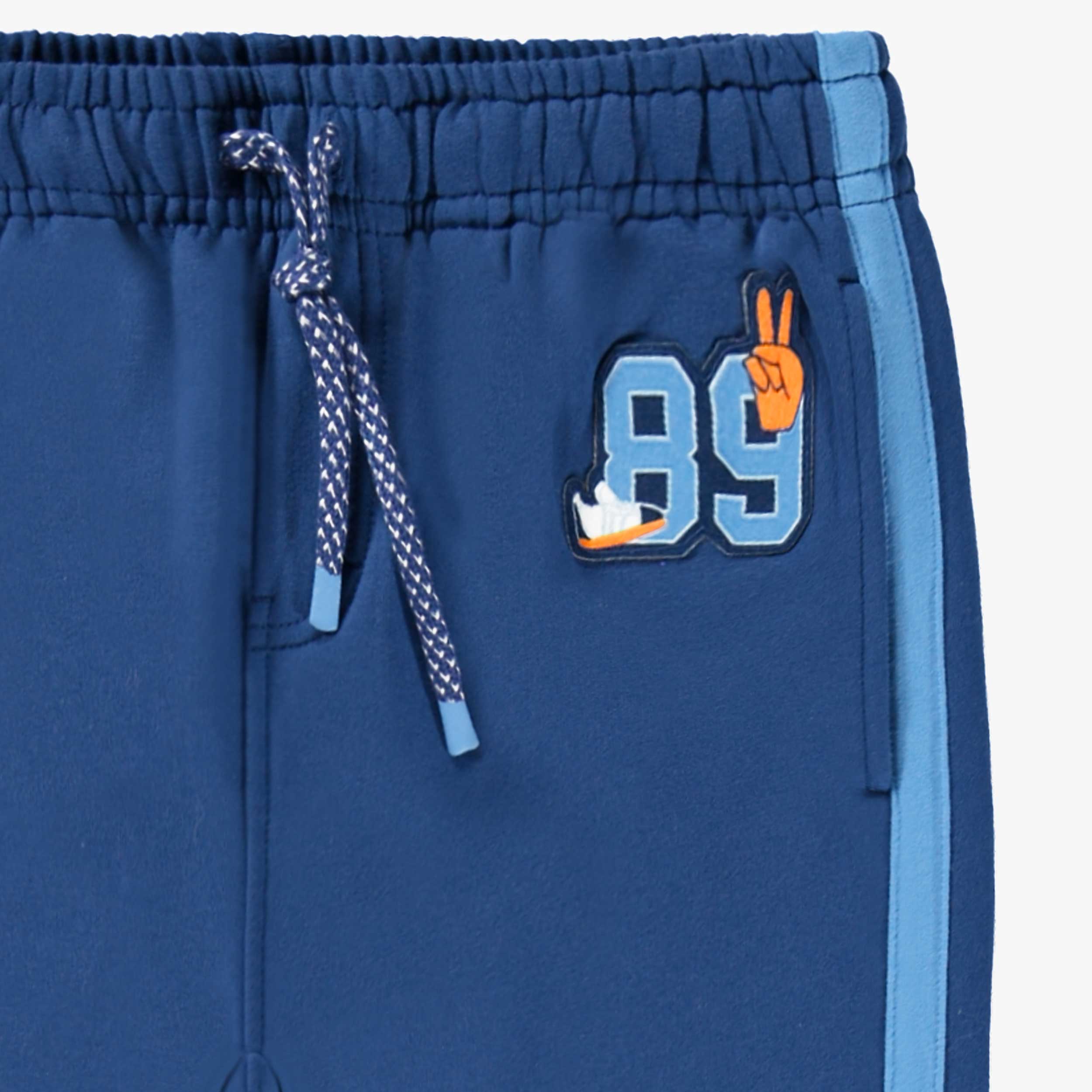 Zoom écusson du pantalon bleu style jogger, enfant
