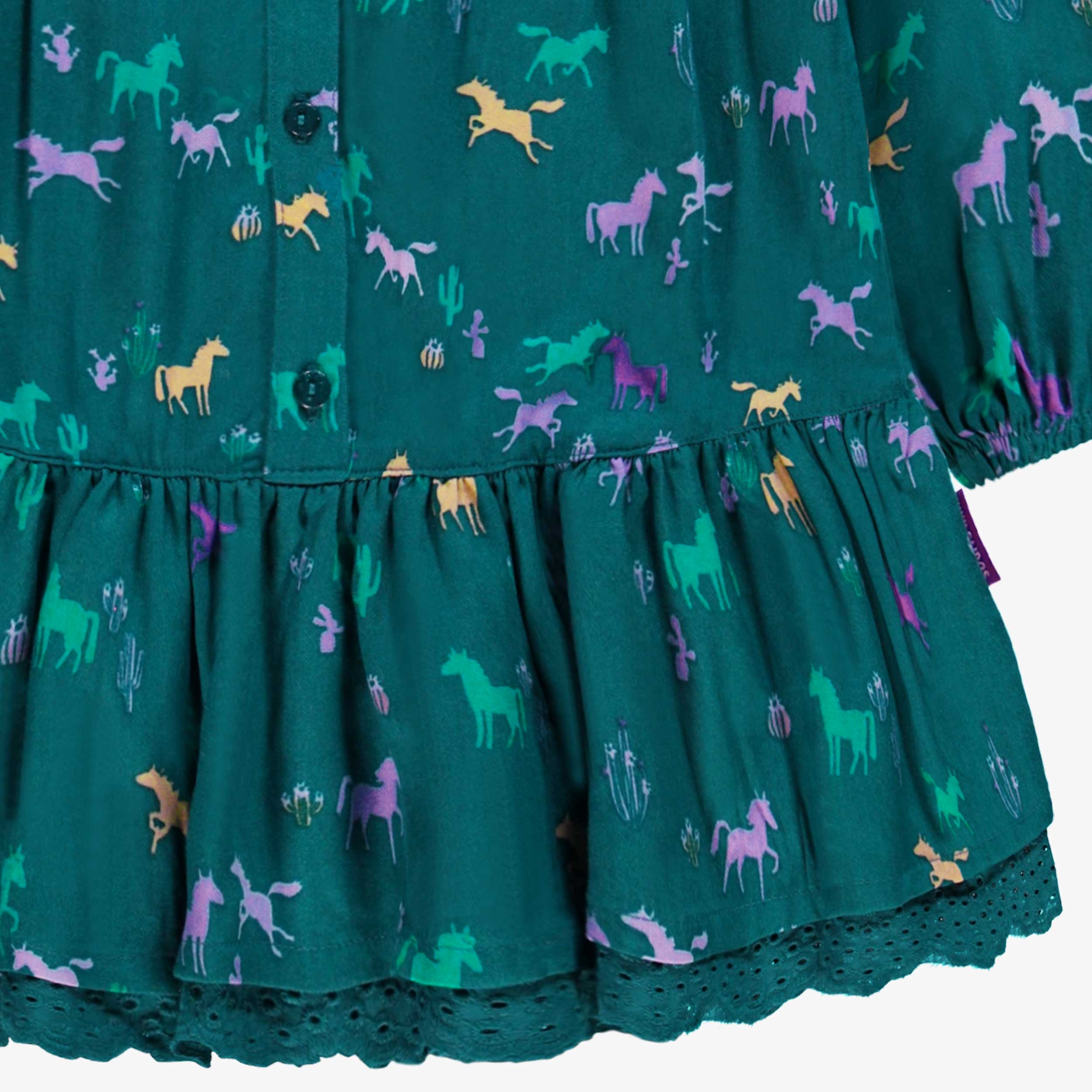 Zoom détails bas de la robe turquoise à motifs, enfant