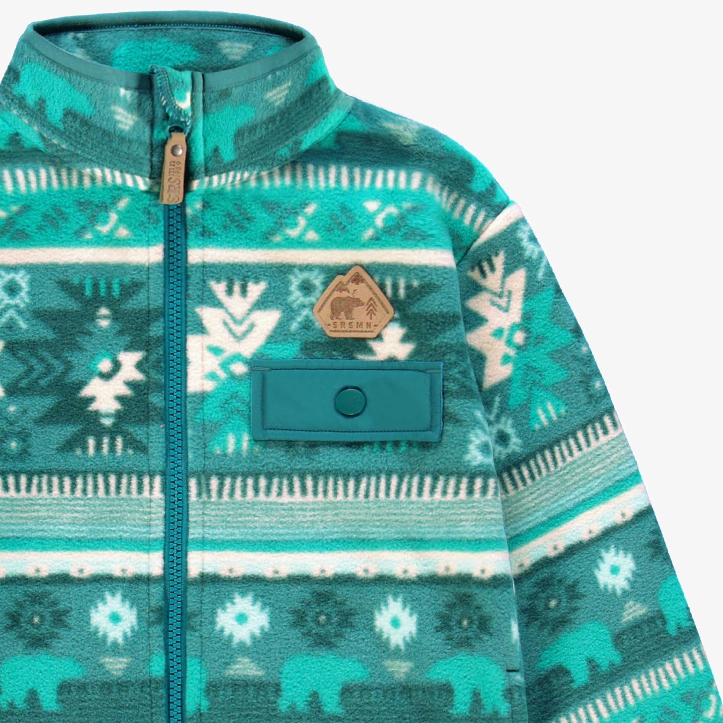 Zoom détails de la veste turquoise en polar avec motifs, enfant
