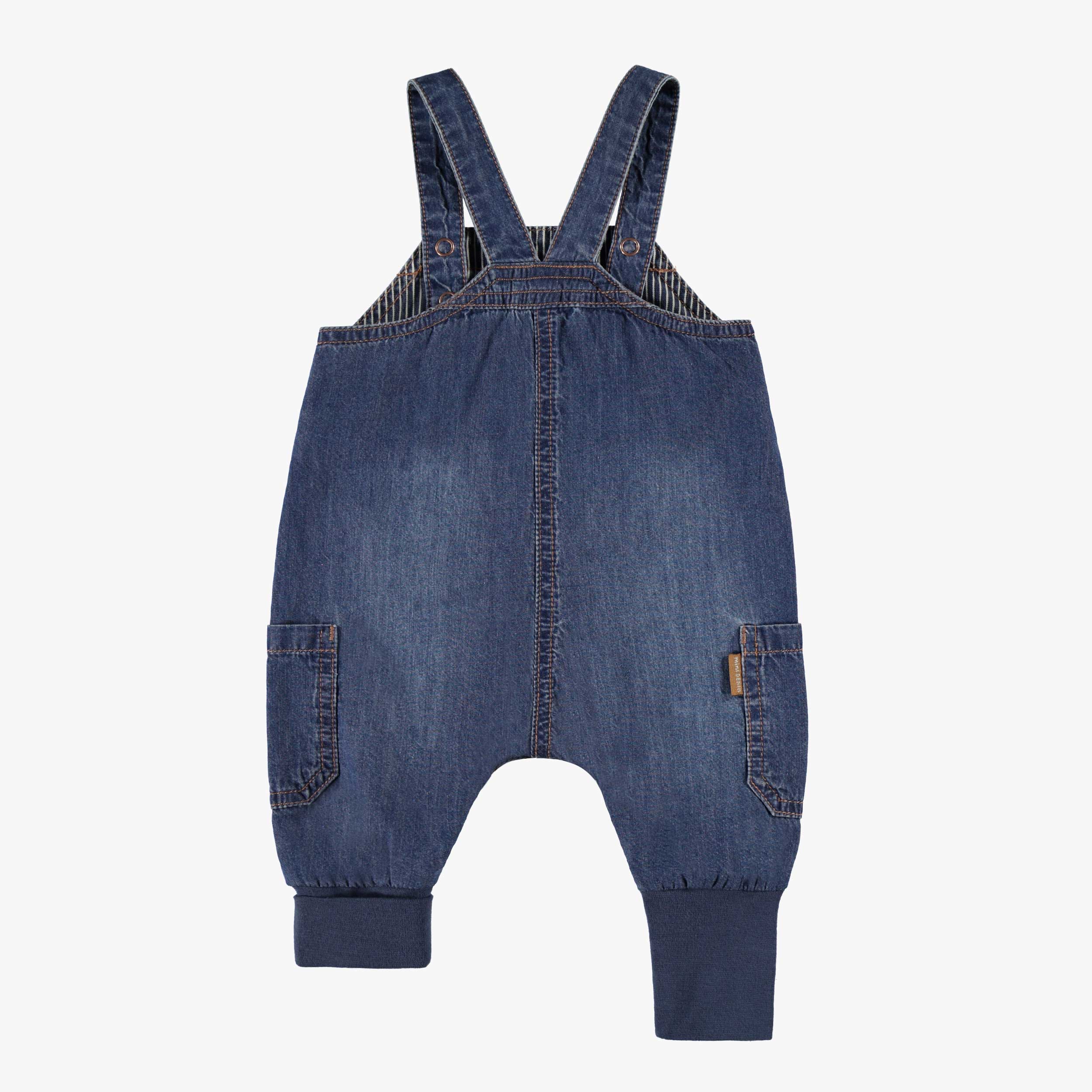 Dos de la salopette bleue en denim, naissance