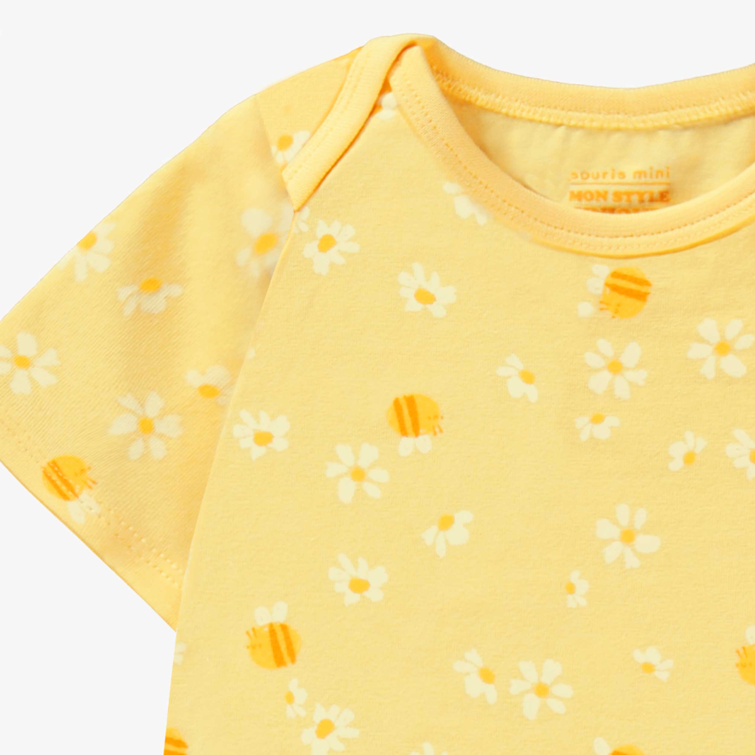 Détail au col du cache-couche jaune à motif floral, bébé