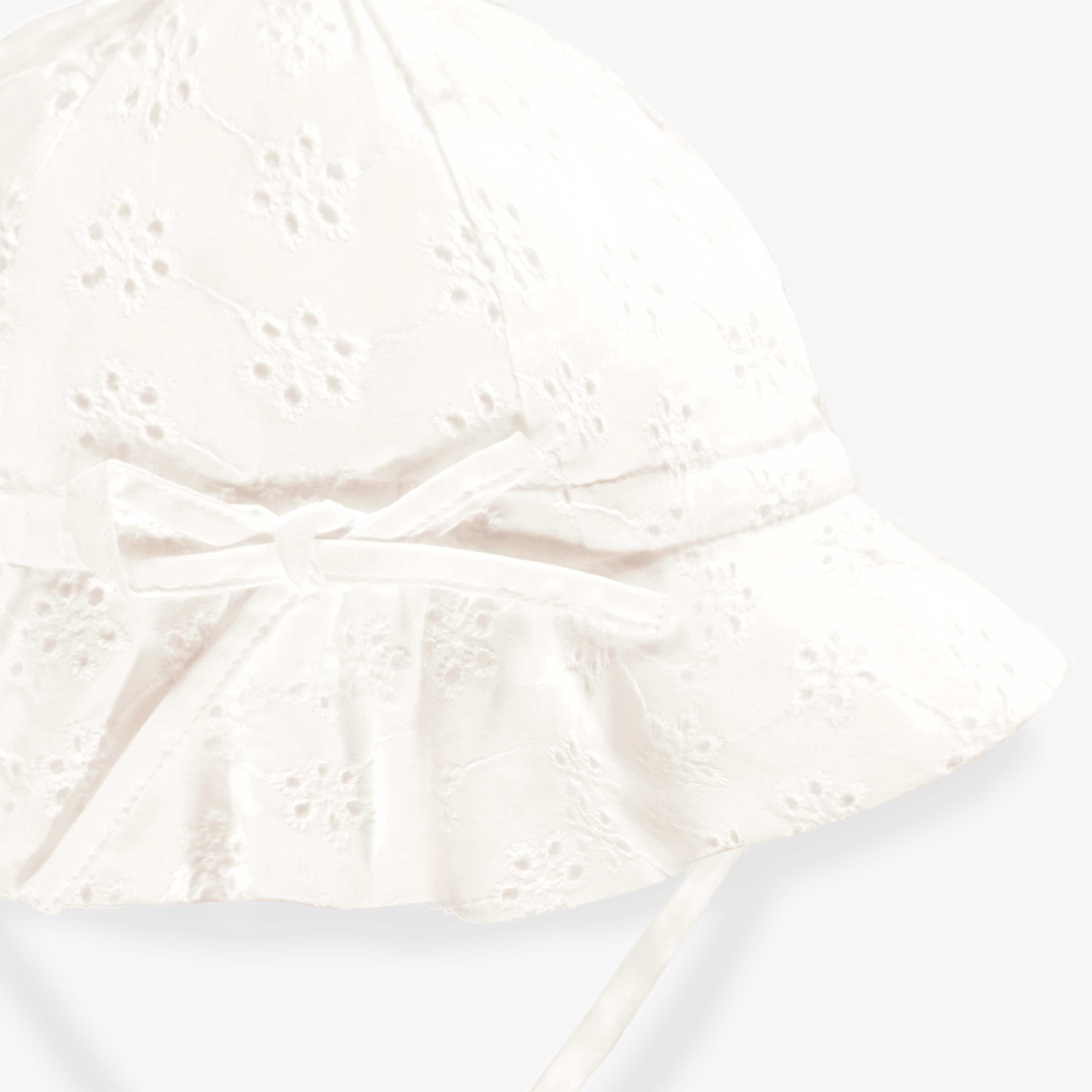 Détail du dos du chapeau blanc en broderie anglaise, bébé