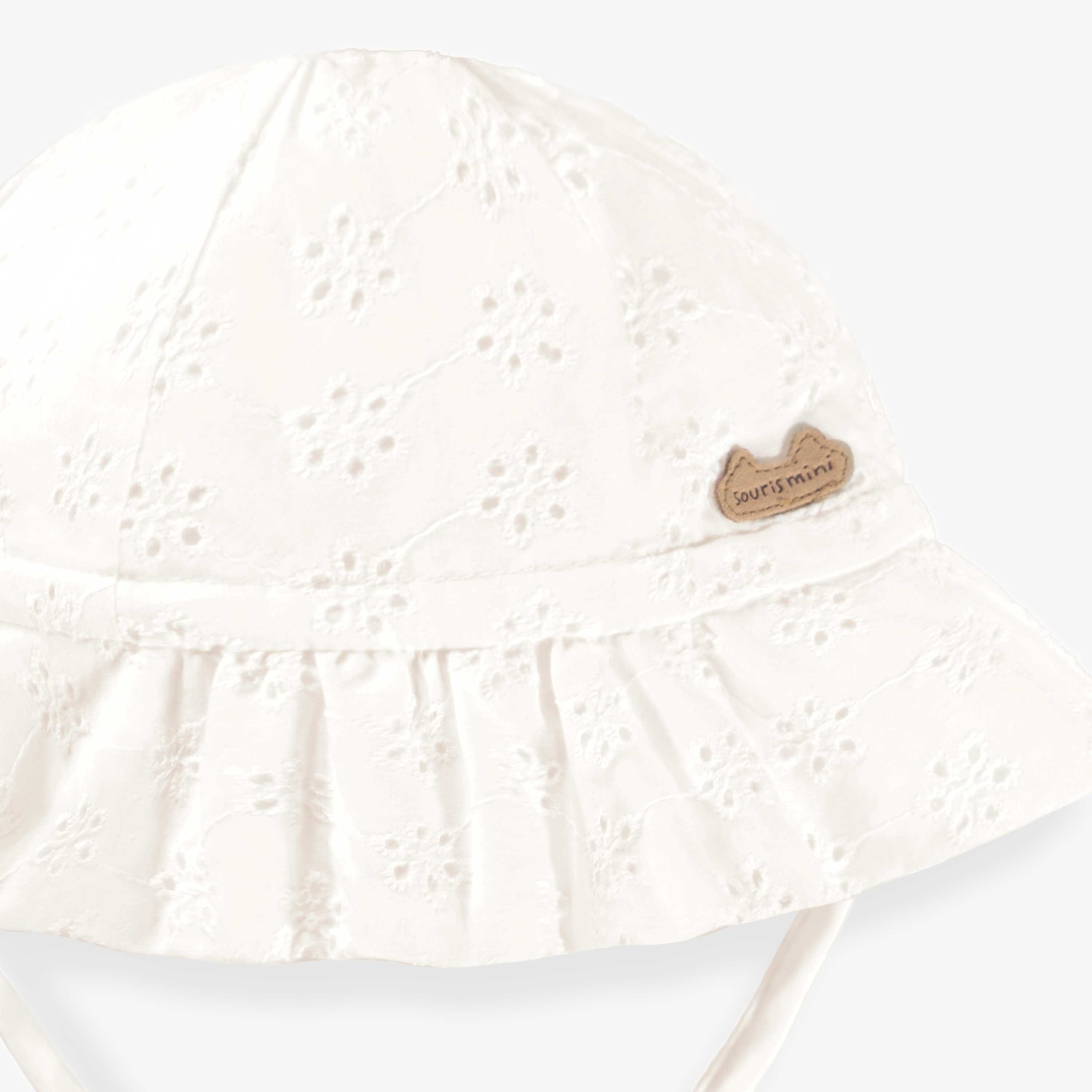 Détail de devant du chapeau blanc en broderie anglaise, bébé