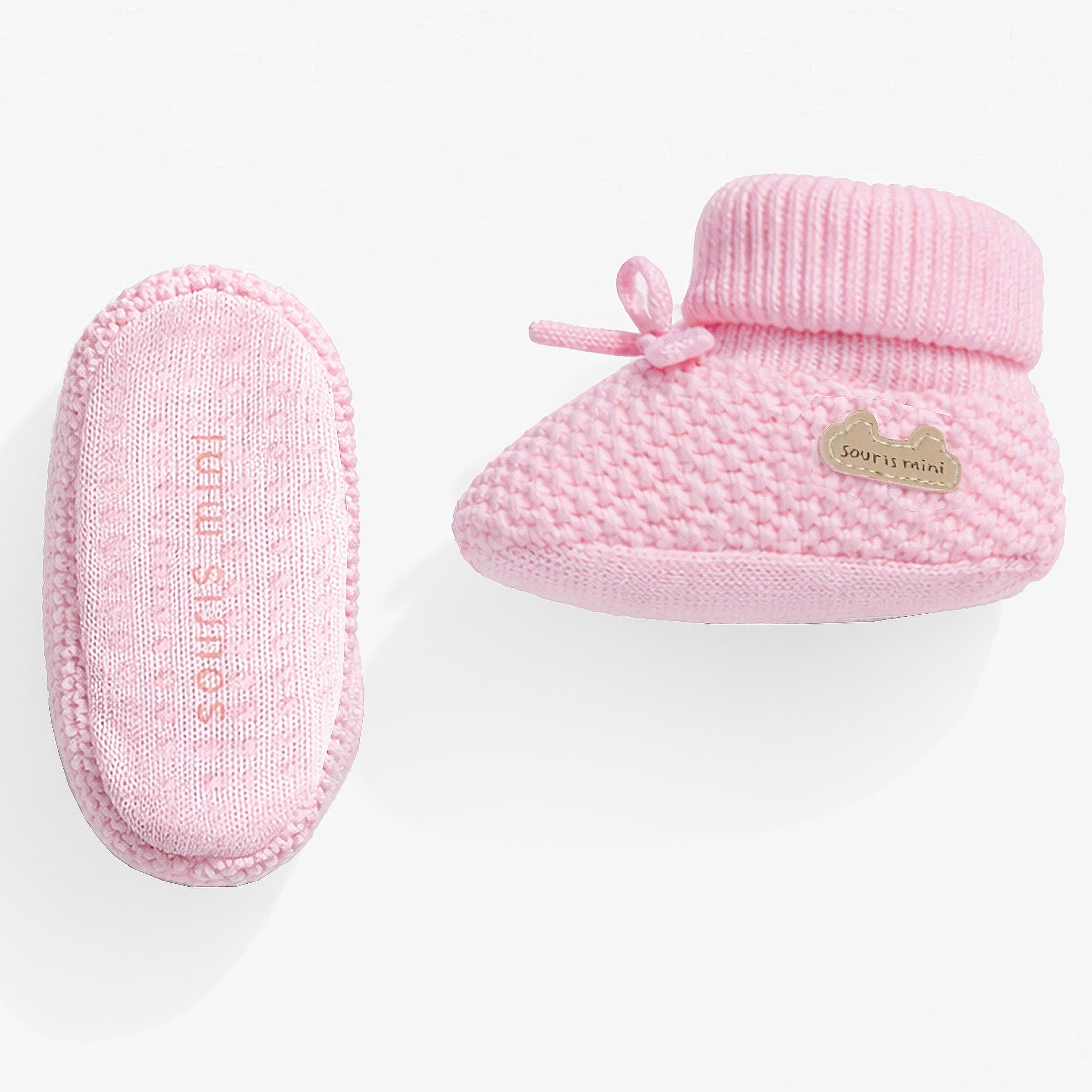 Vue côté et dessous des pantoufles roses en tricot, naissance