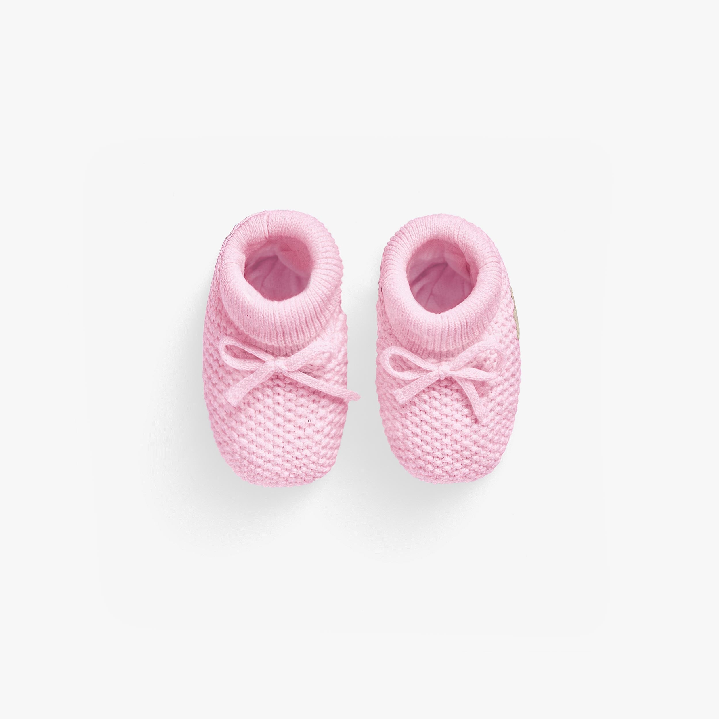 Vue de haut deux pantoufles roses en tricot, naissance