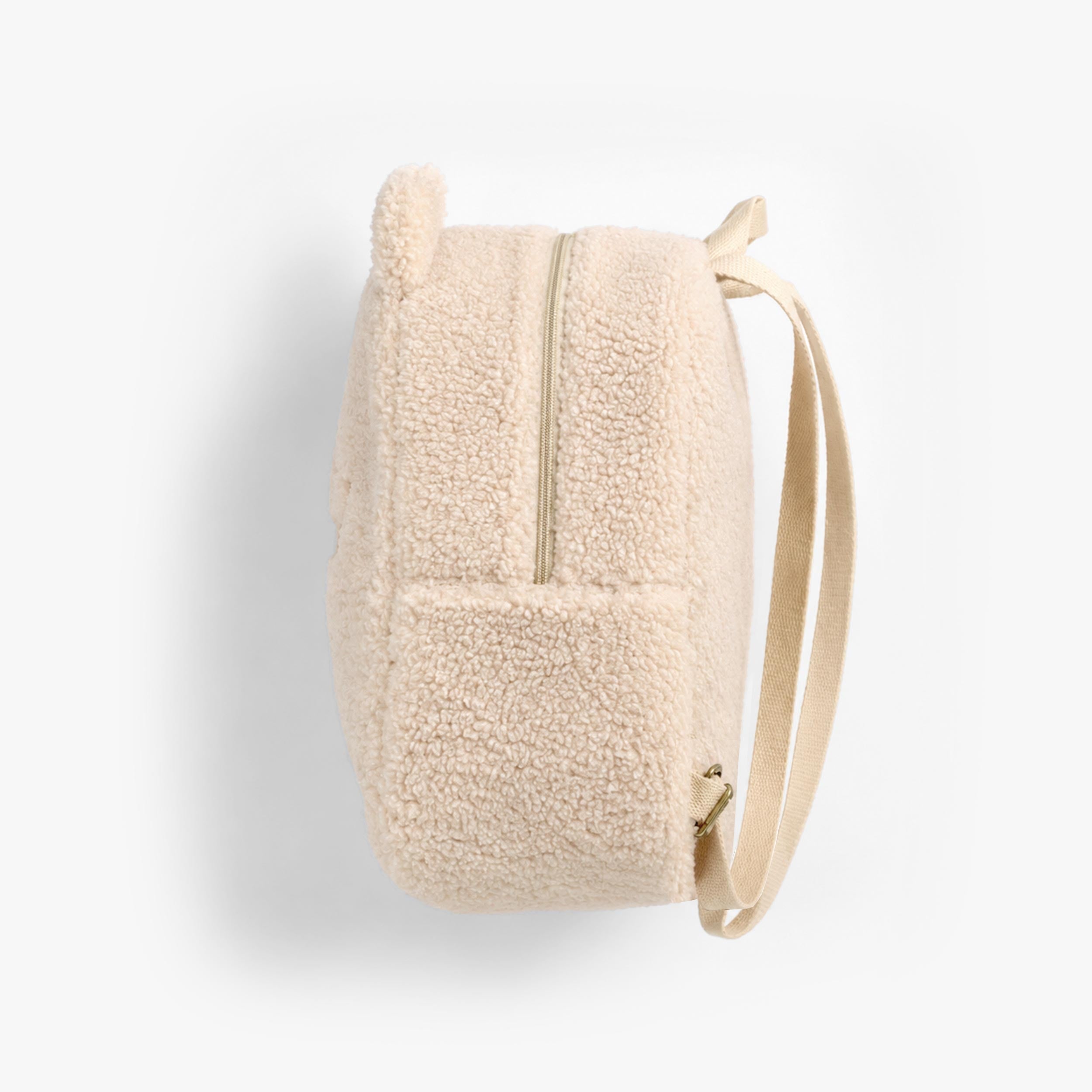 Vue de côté du sac à dos crème en sherpa à visage d’ourson, bébé