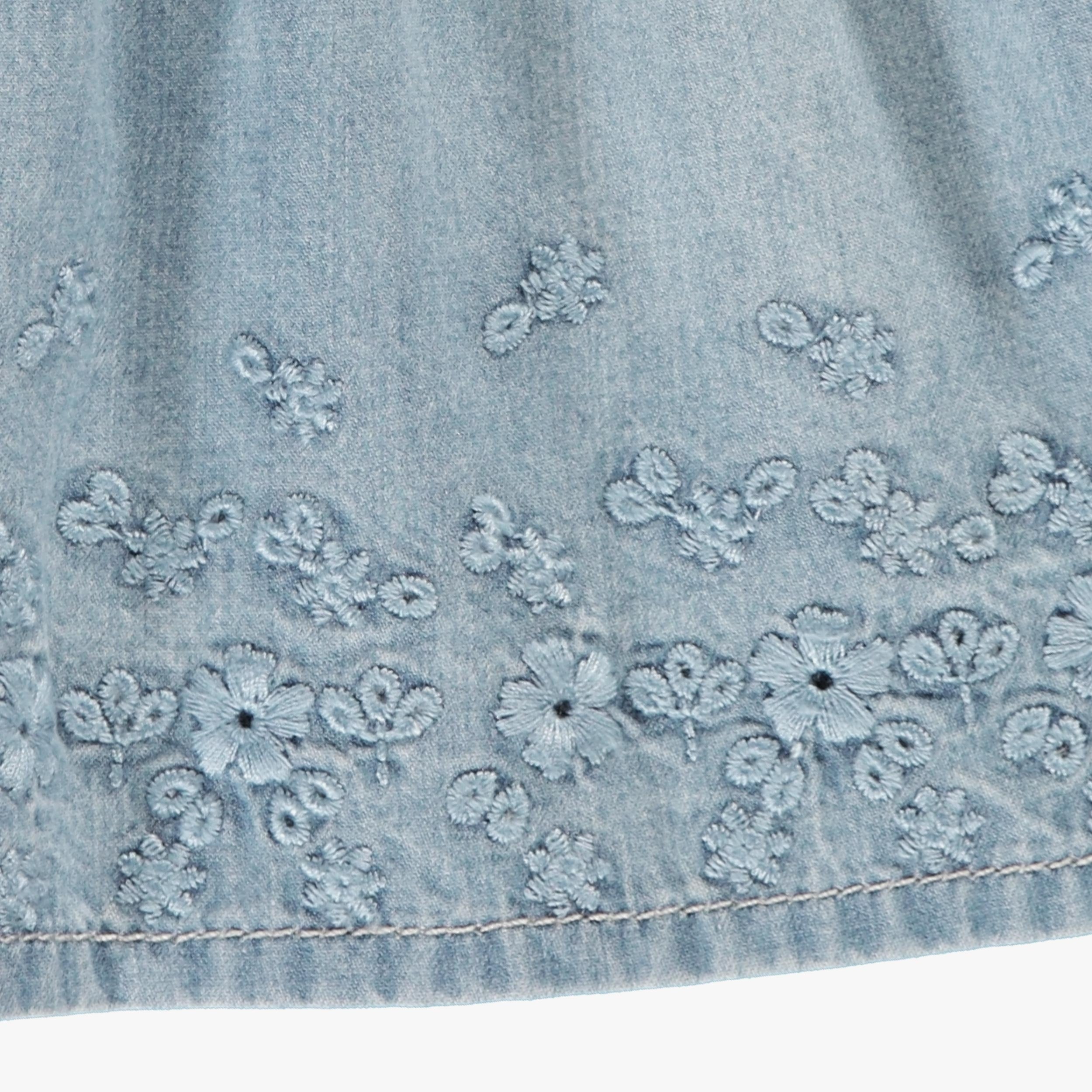 Zoom détails la robe et bloomer en denim avec broderie anglaise, naissance