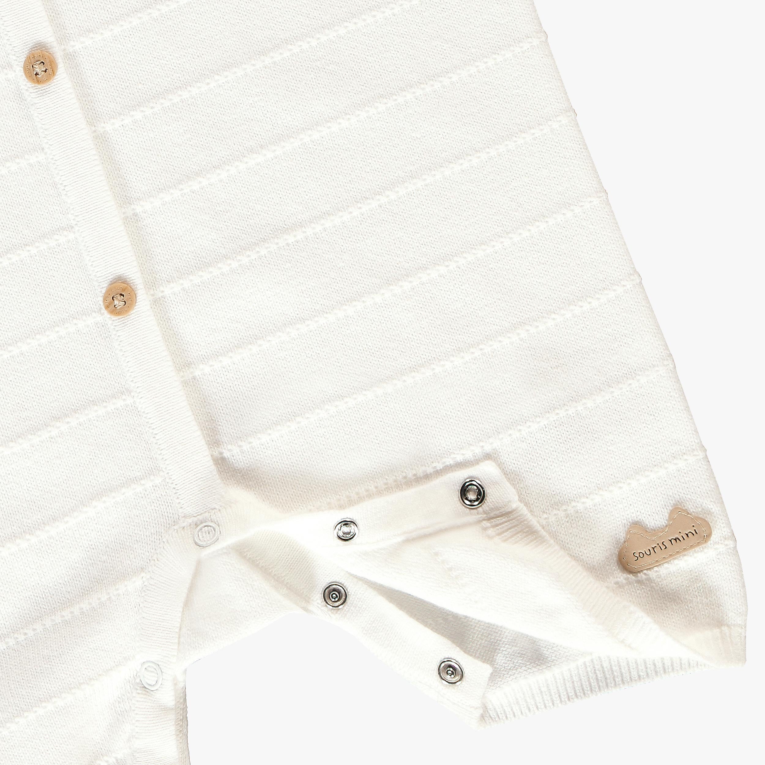 Zoom détails boutons pressions de la barboteuse crème en tricot avec rayures, naissance