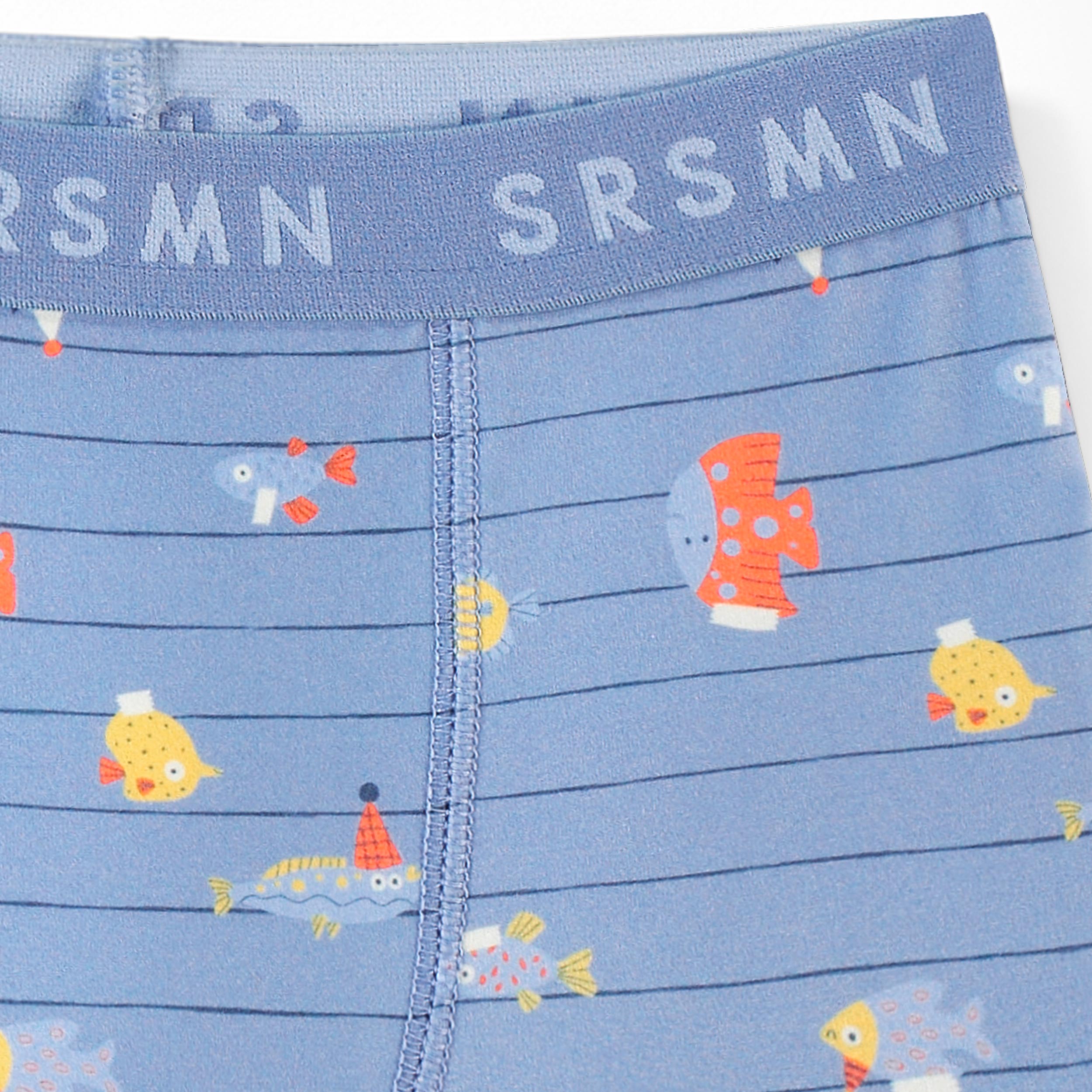 Zoom détails du boxer bleu avec rayures et motifs de poissons, enfant
