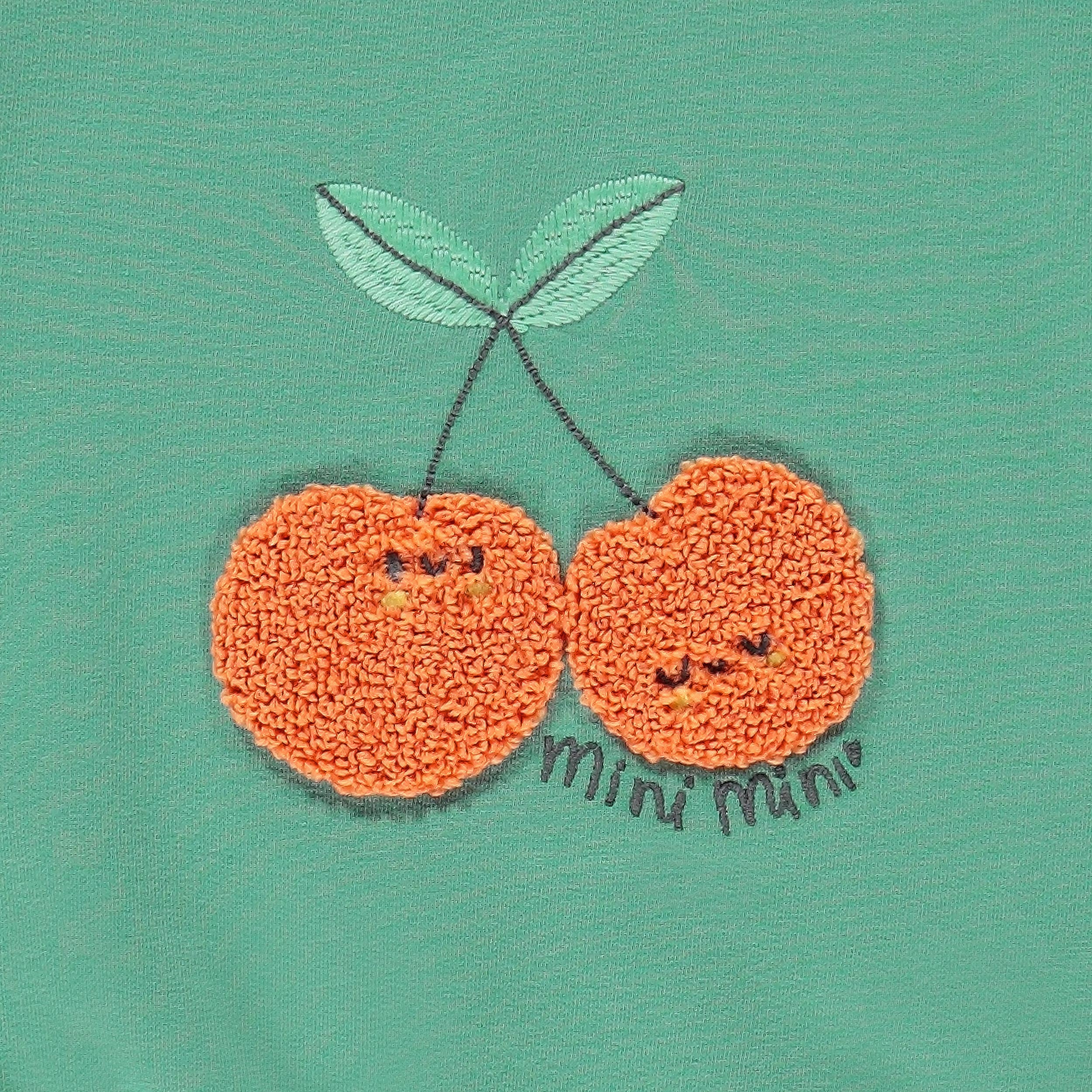 Zoom détails du chandail vert avec cerises, naissance