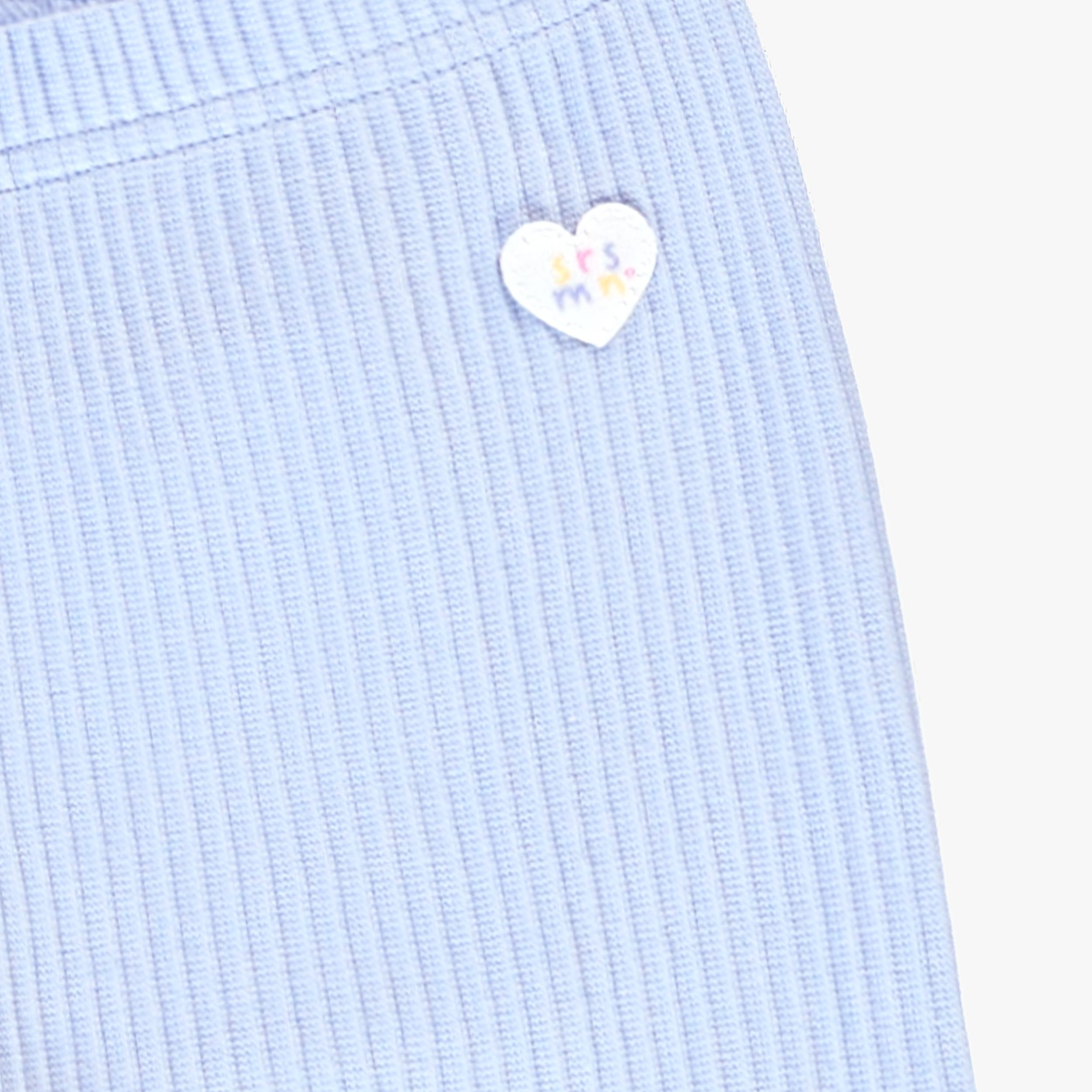 Zoom détails écusson du legging court bleu en tricot côtelé, enfant