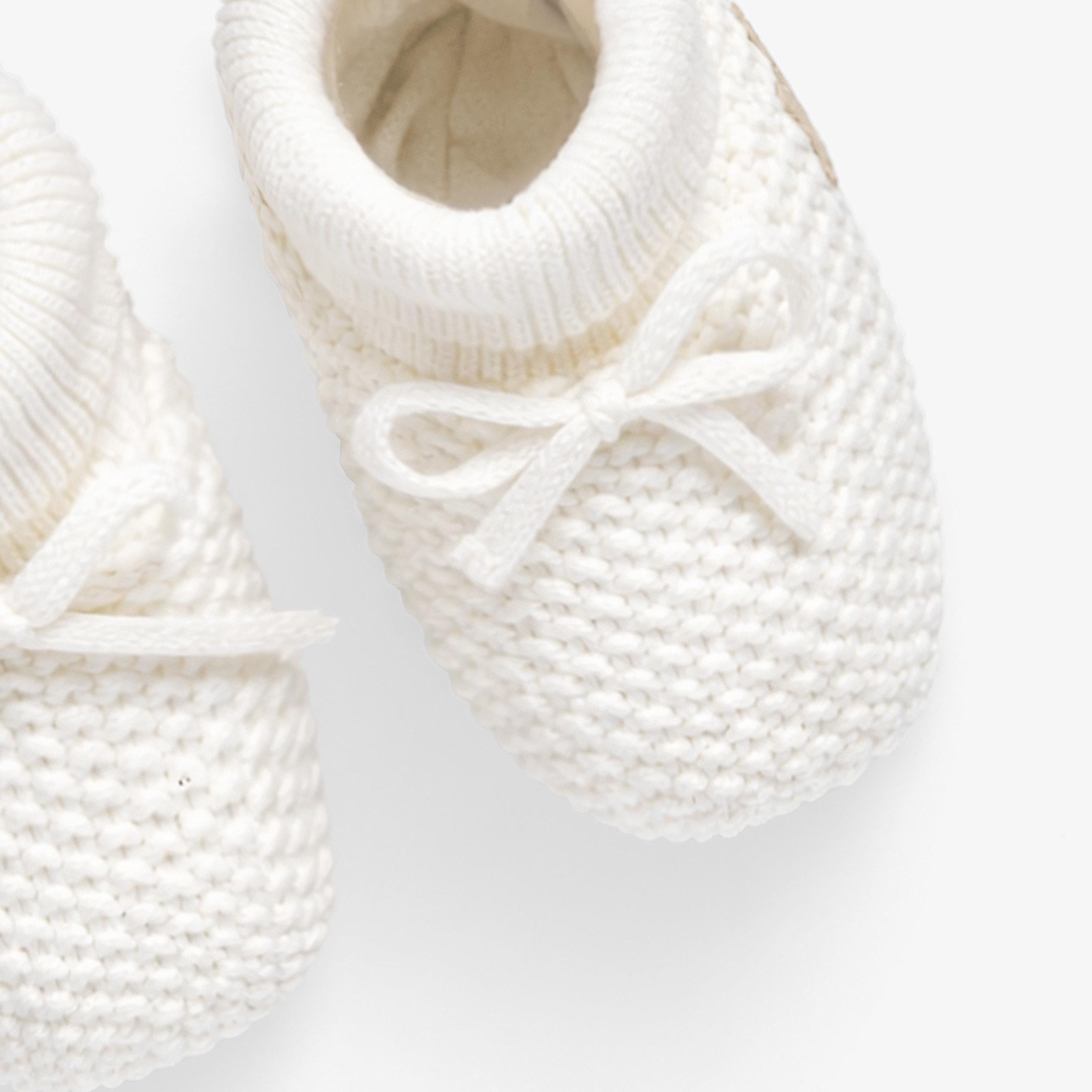 Vue de haut des pantoufles crème en tricot, naissance