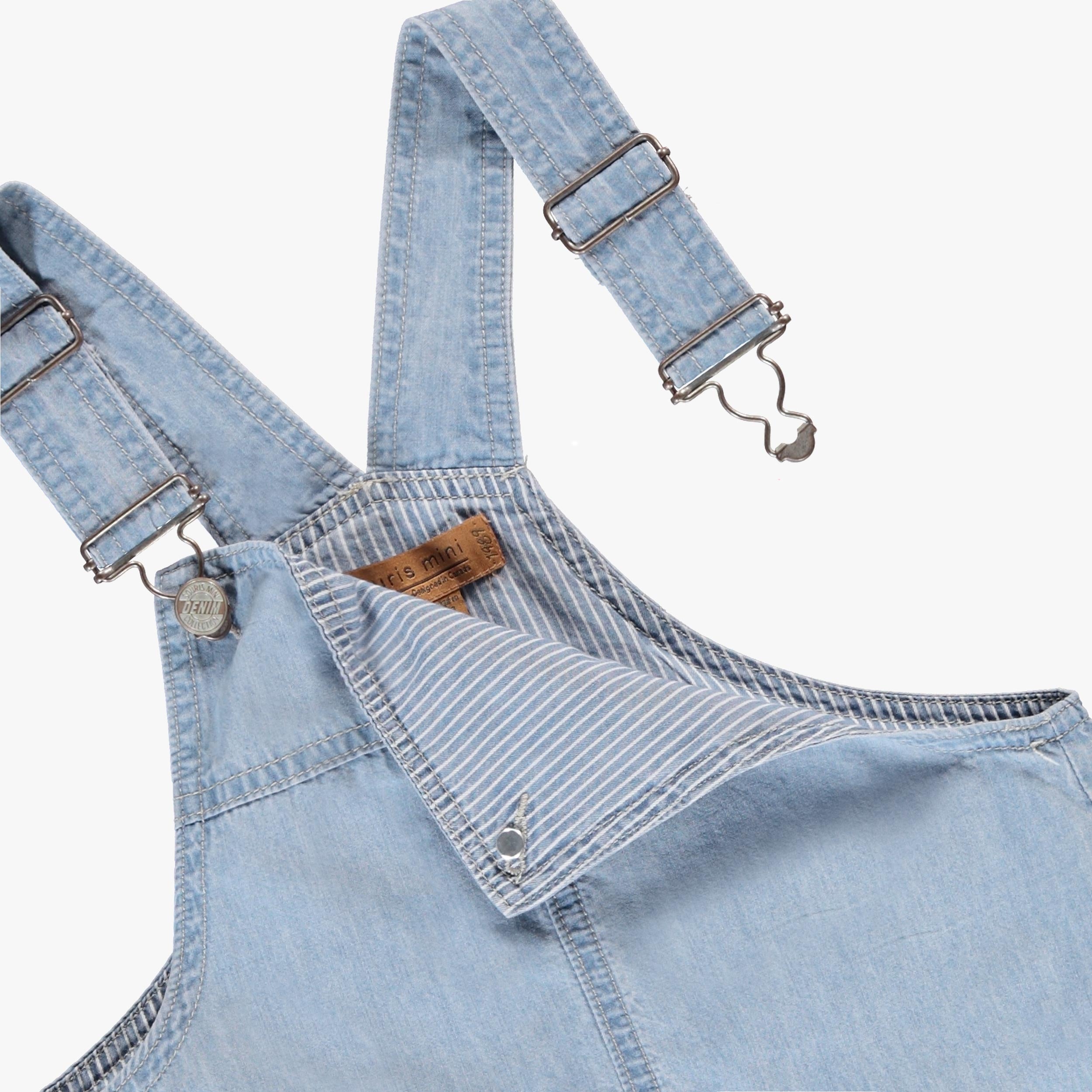 Zoom détails des attaches de la salopette bleue en denim, enfant