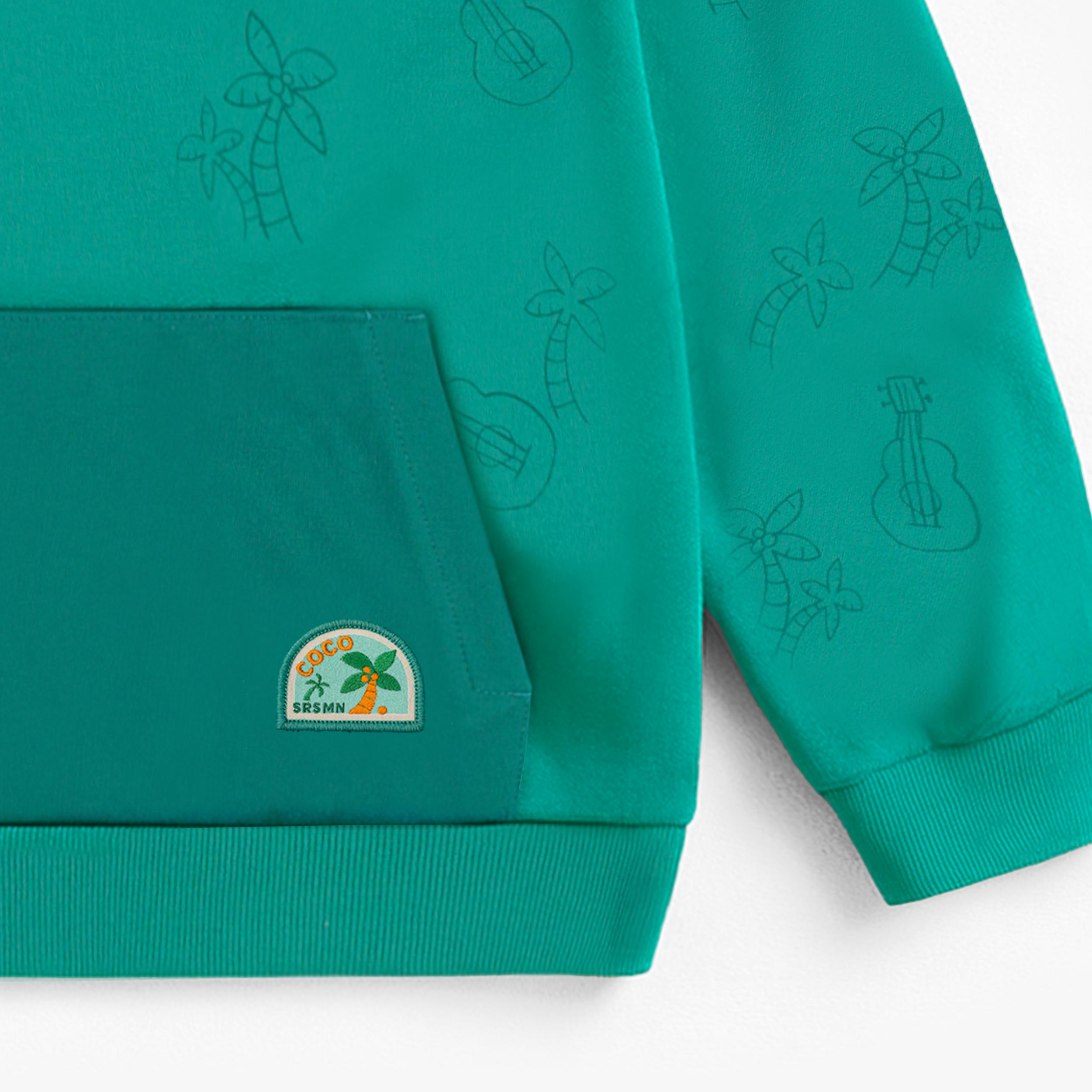 Zoom détails du chandail à capuchon turquoise à motifs de palmiers et guitares, enfant