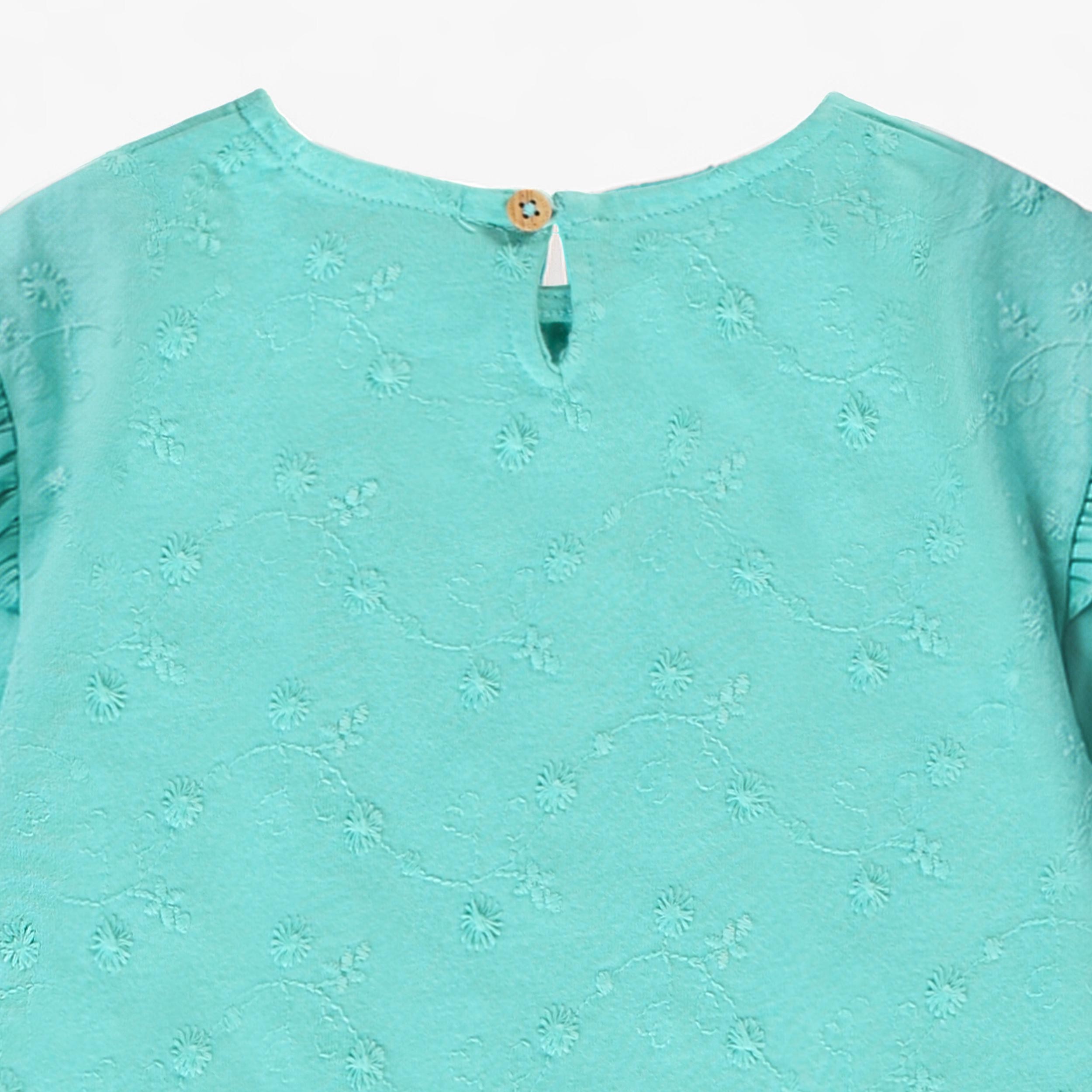 Zoom détail dos du t-shirt turquoise avec broderies, bébé