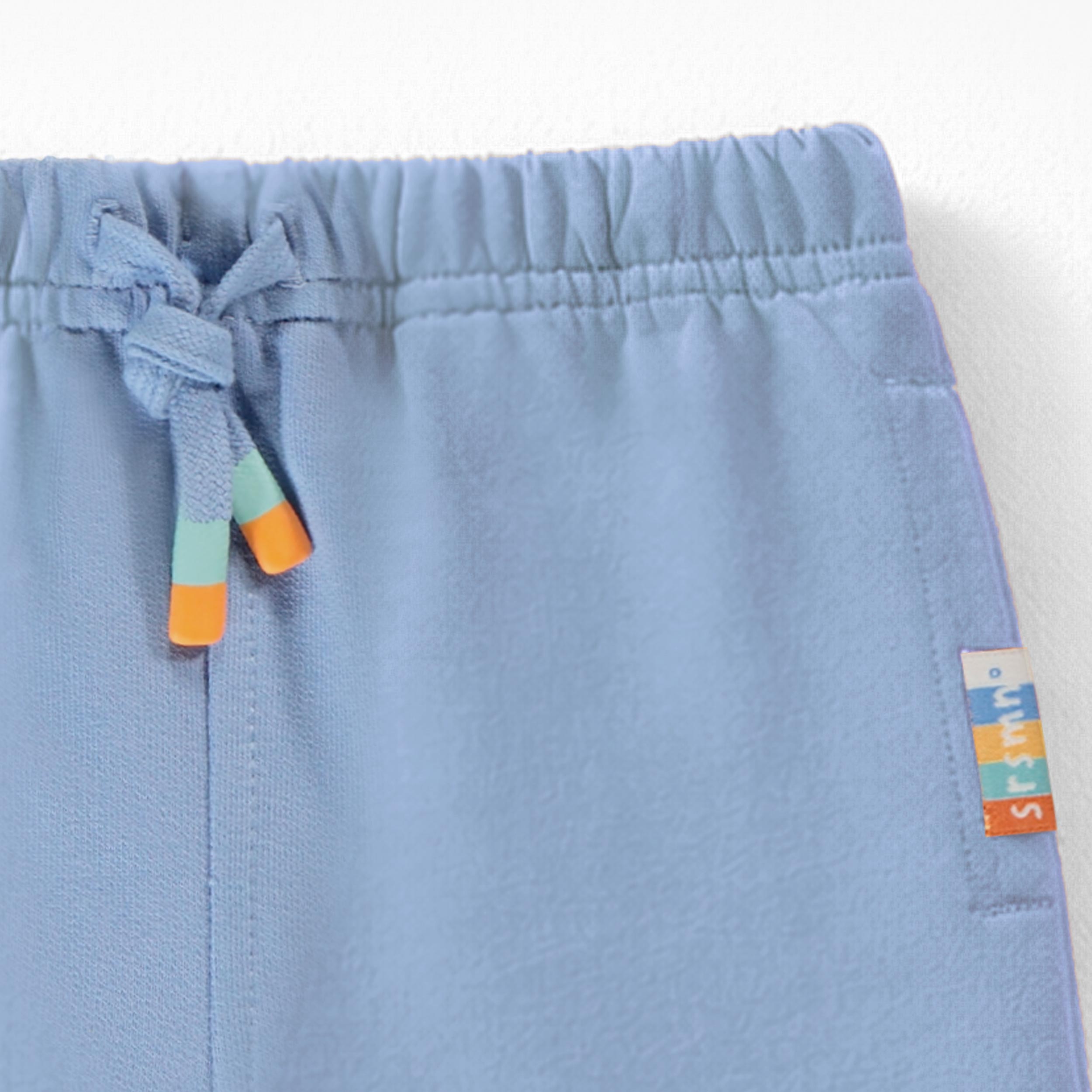 Zoom détails du pantalon bleu style jogger, bébé