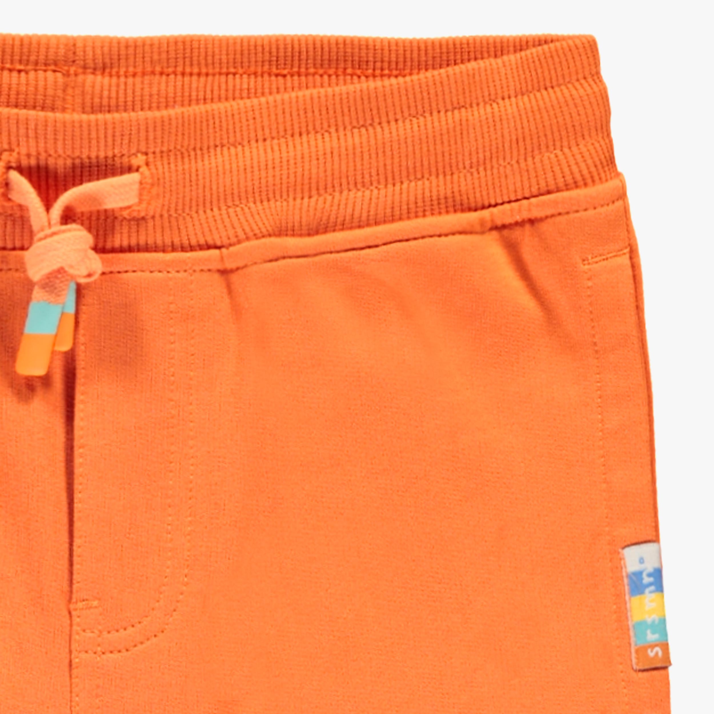 Zoom détails du pantalon orange style jogger, enfant