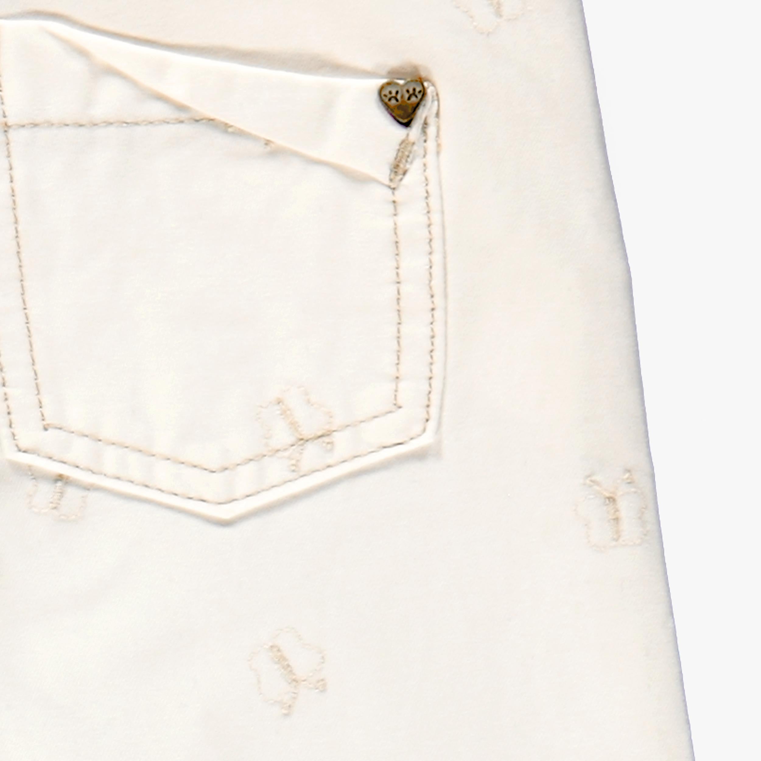 Zoom détails de la poche arrière du jean crème avec broderies de papillons, enfant