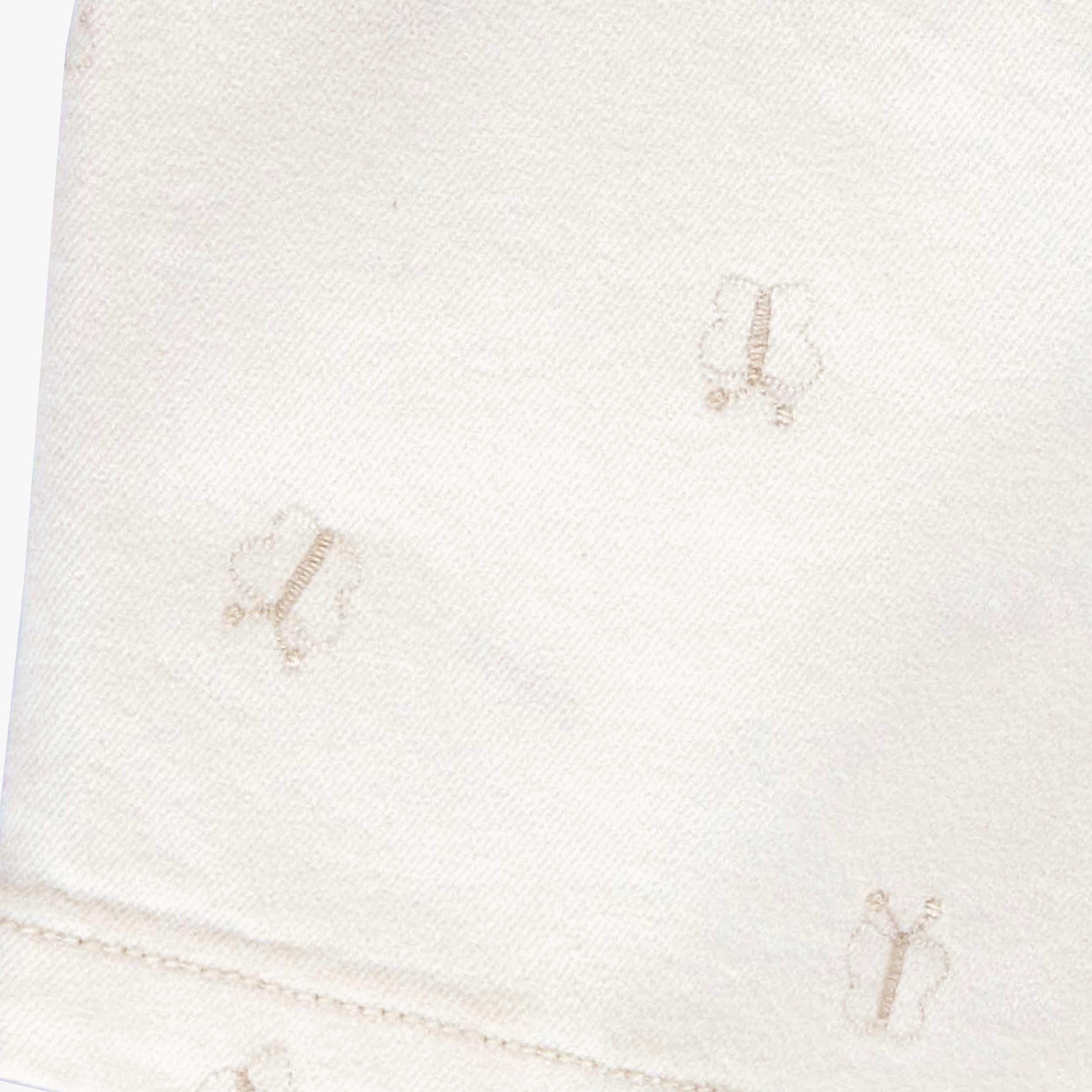 Zoom détails de la robe crème en denim avec broderies de papillons, bébé