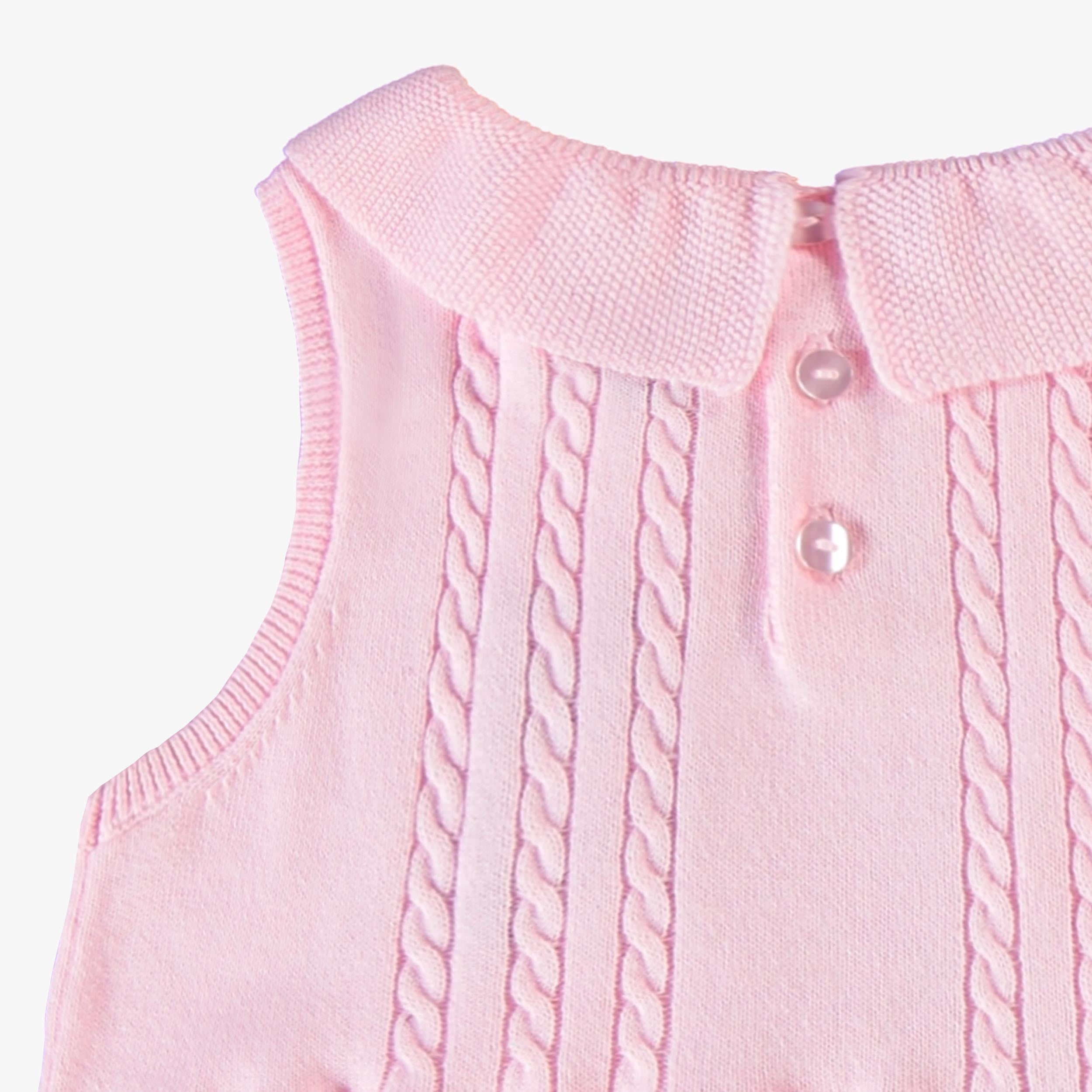 Zoom détails torsade au dos de la robe rose en tricot, enfant