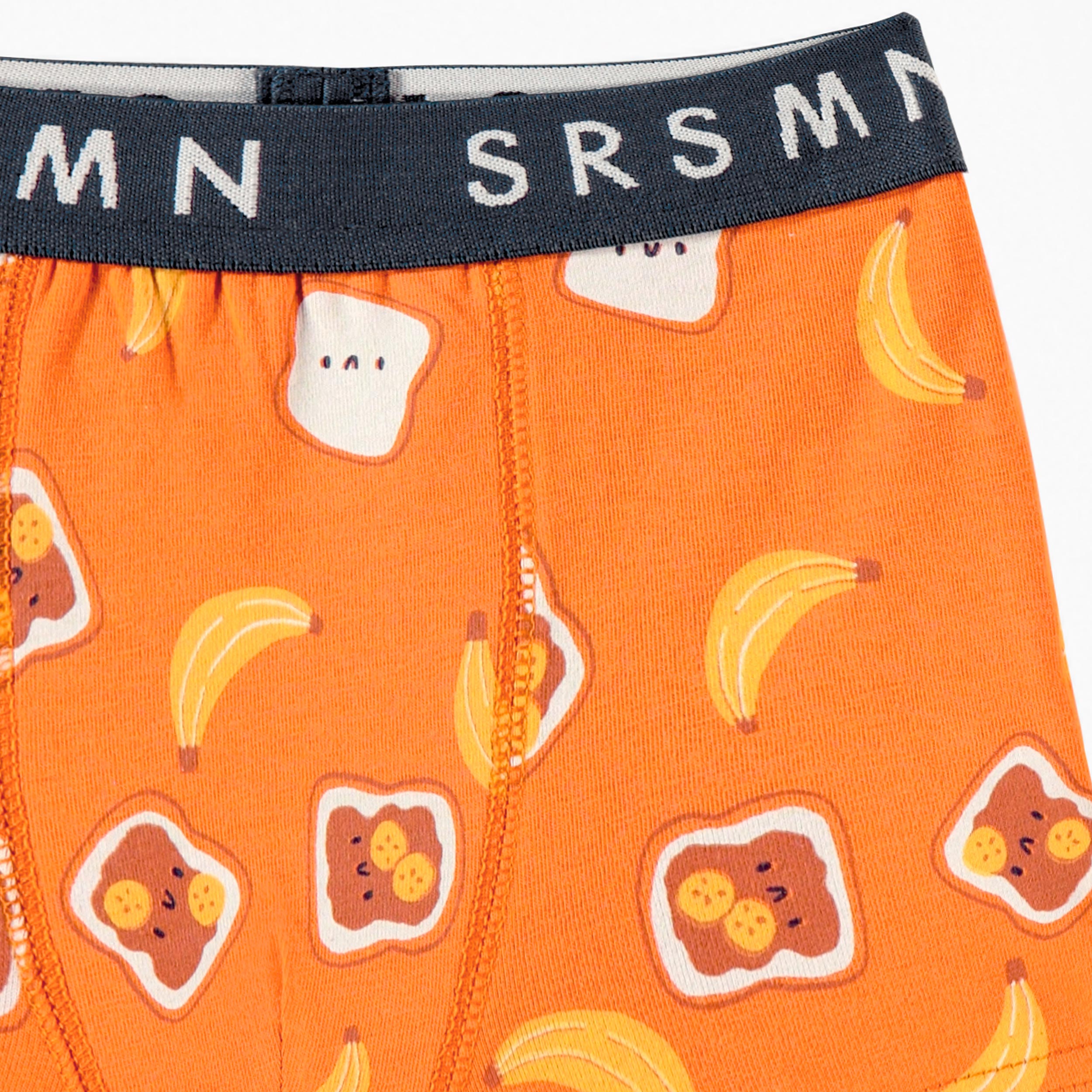 Zoom détails du boxer ajusté orange à imprimé de tartines et bananes, enfant