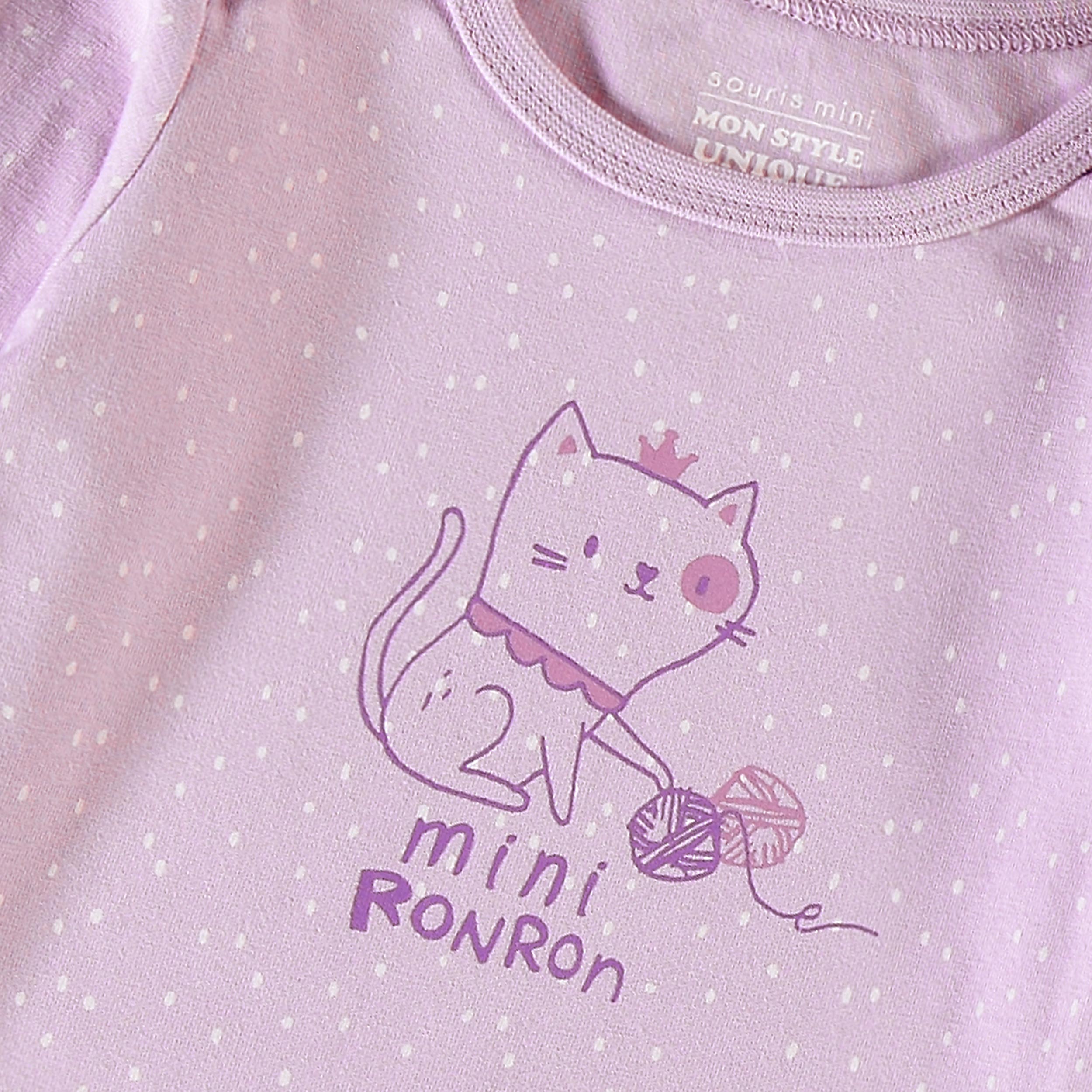 Gros plan de l’illustration de fraise sur le cache-couche rose pour bébé en jersey de coton extensible.