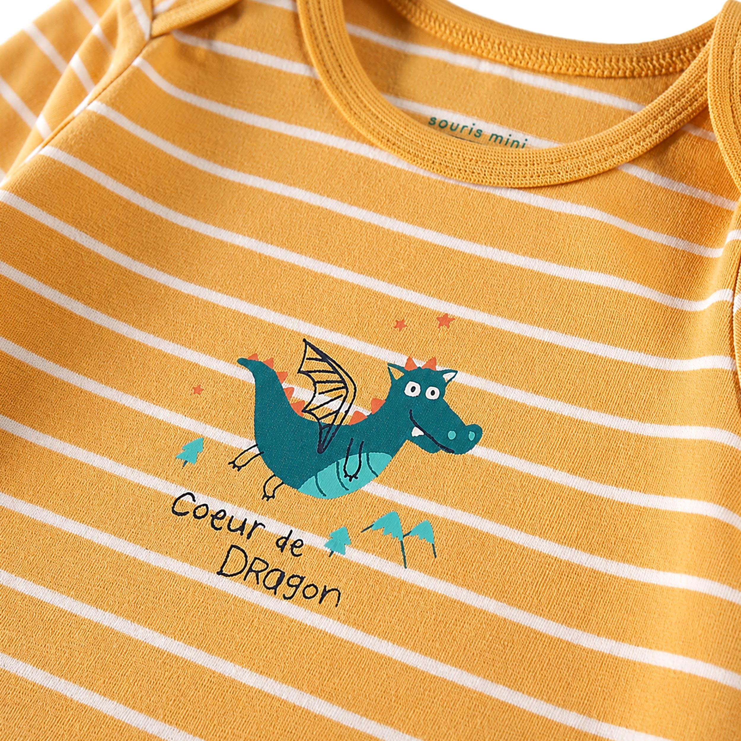 Zoom détails du cache-couche jaune à rayures et illustration de dragon, bébé