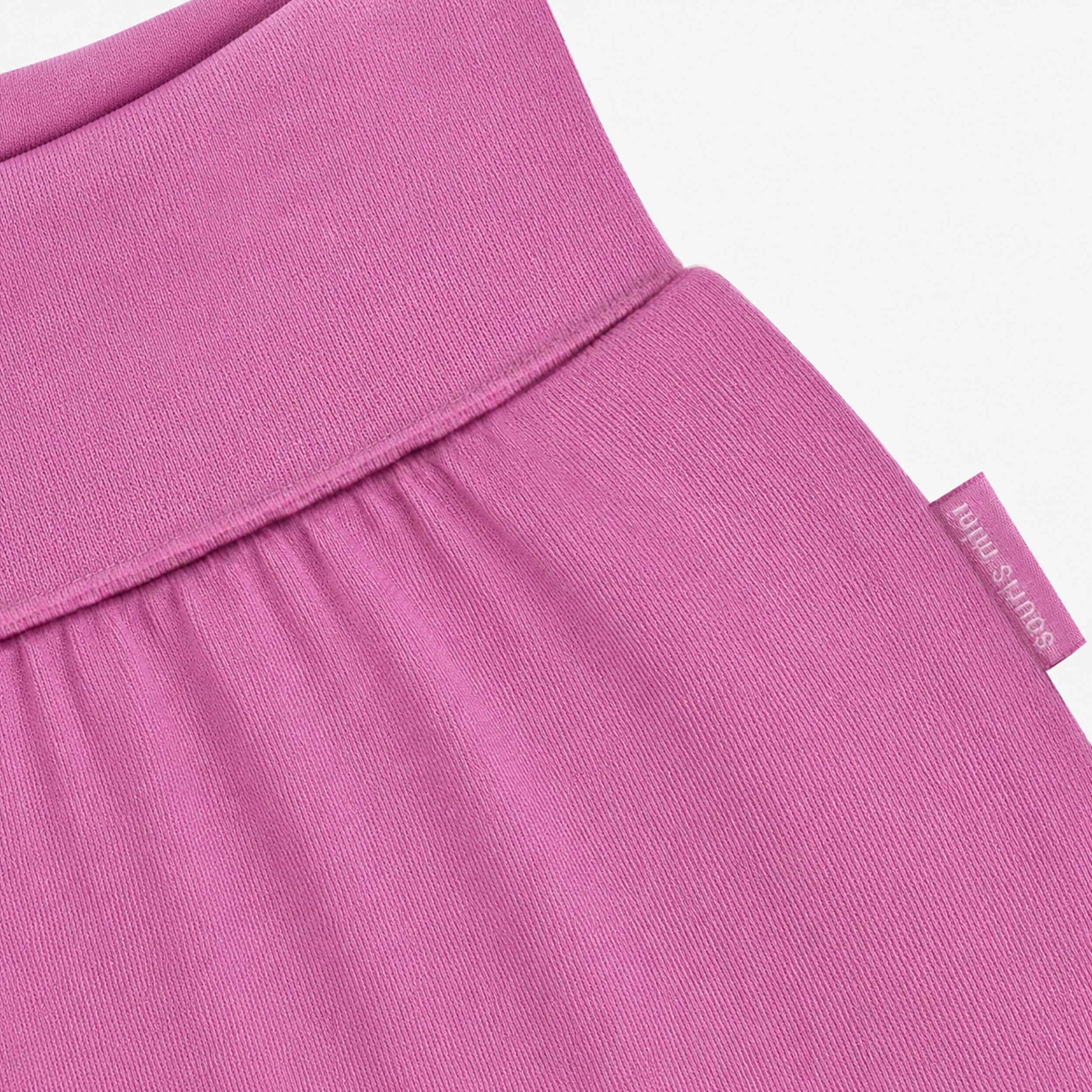 Zoom du pantalon évolutif mauve pour bébé en jersey de coton extensible avec taille et chevilles repliables ajustables.