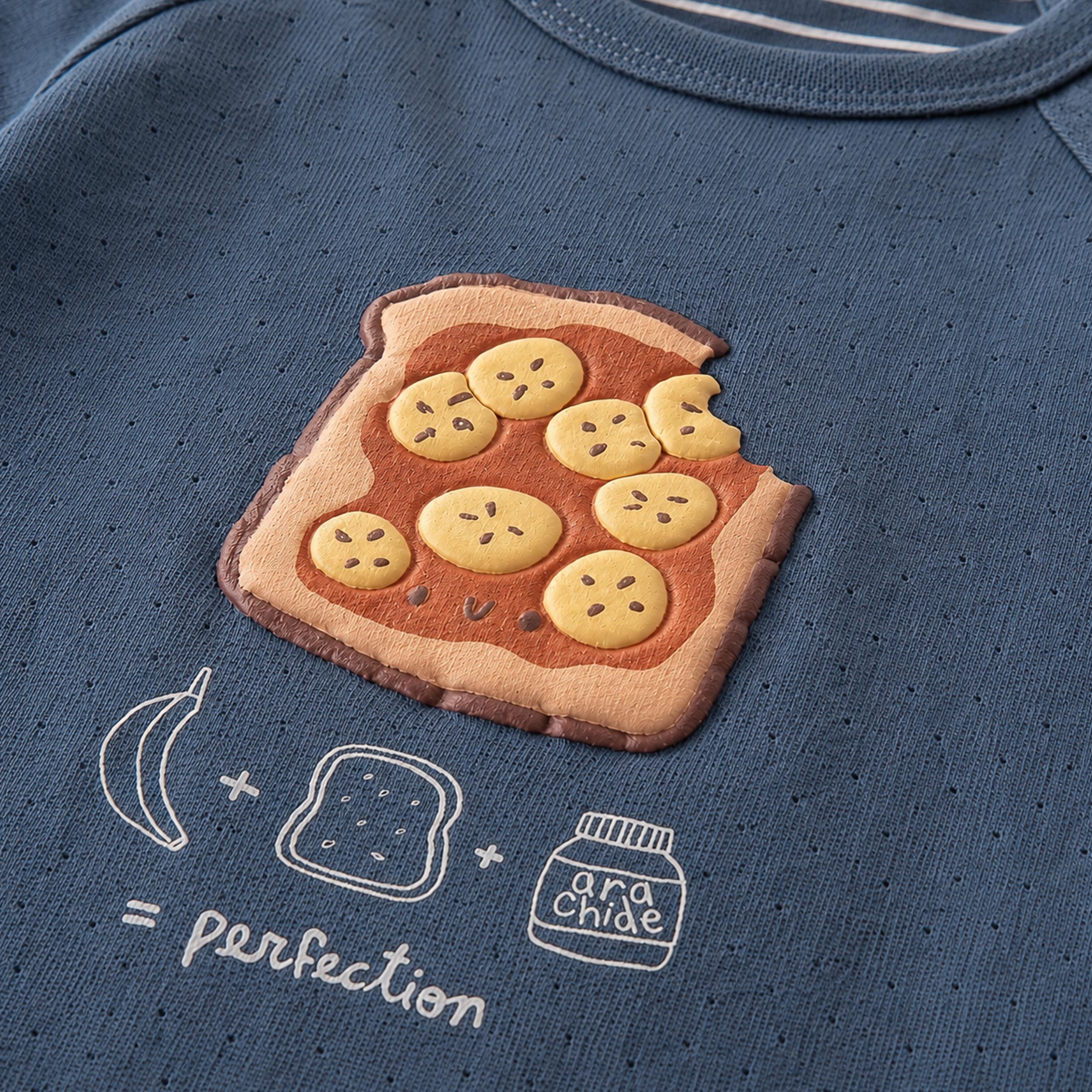 Zoom détails du pyjama deux pièces bleu à illustration de tartine, enfant