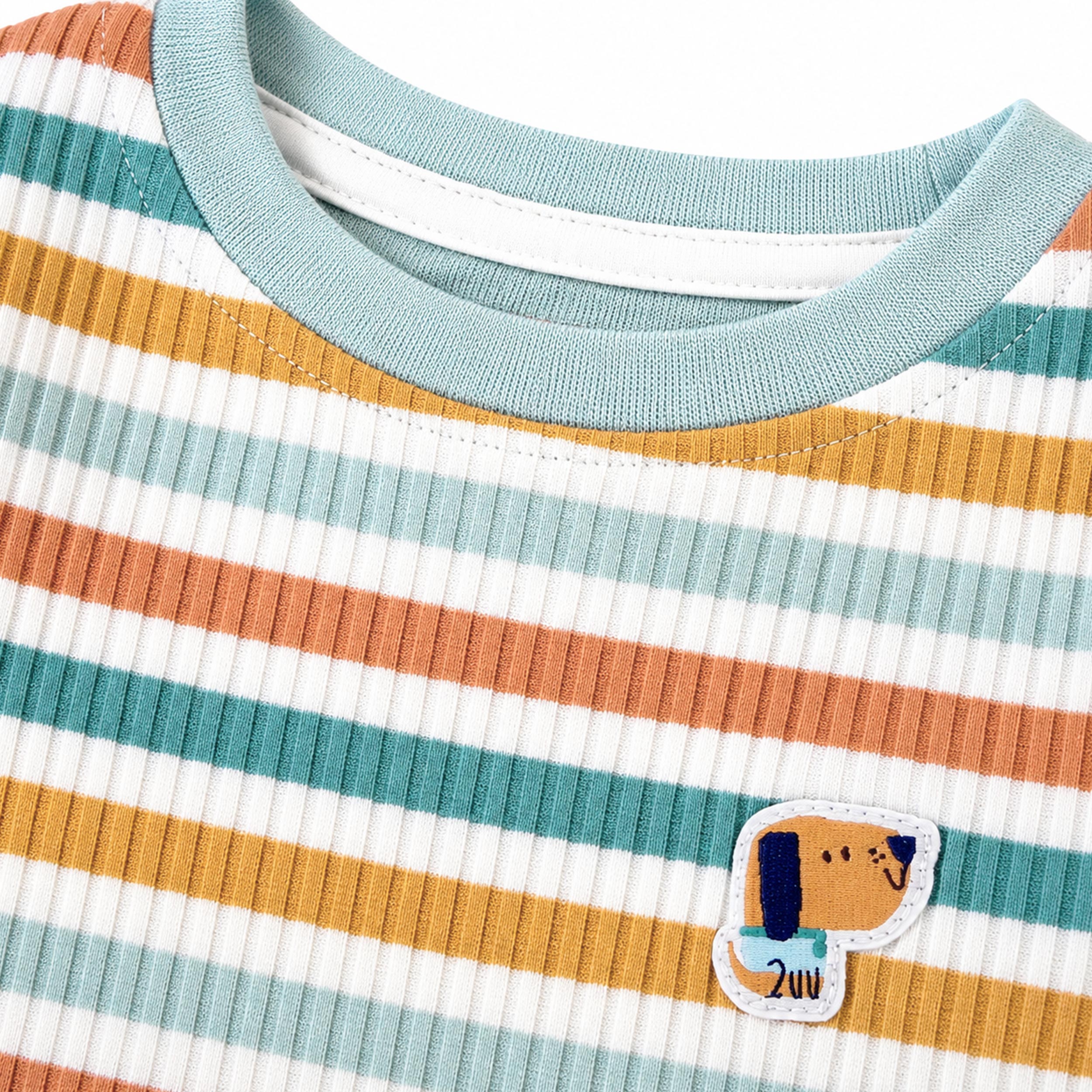 Gros plan d'un pyjama pour enfant a rayures bleu, orange et blanc avec col bleu et ecusson chien.