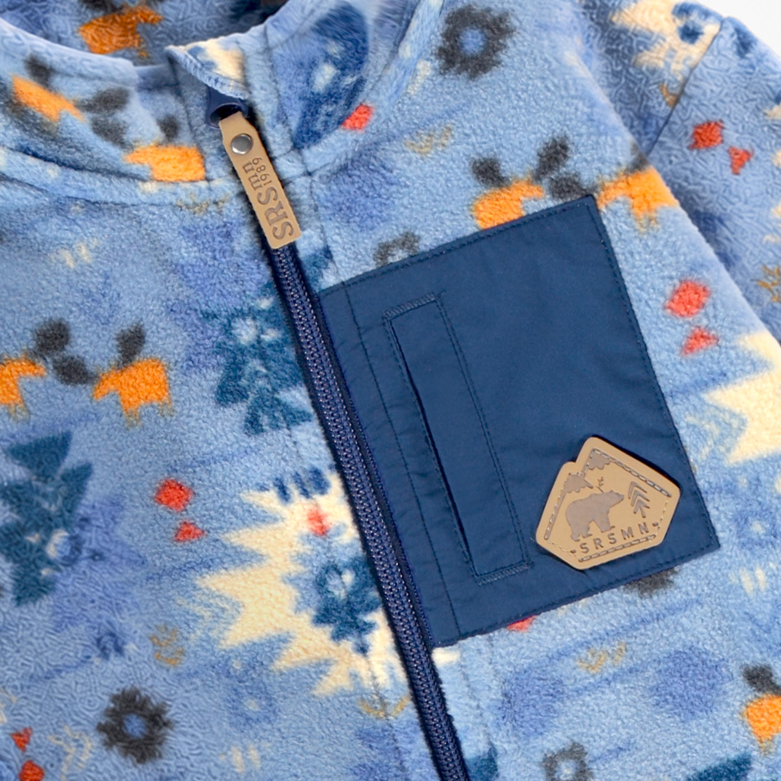 Zoom détails de la poche de la veste bleue en polar à motifs pour bébé Souris Mini avec fermeture éclair, poche poitrine et poches latérales.
